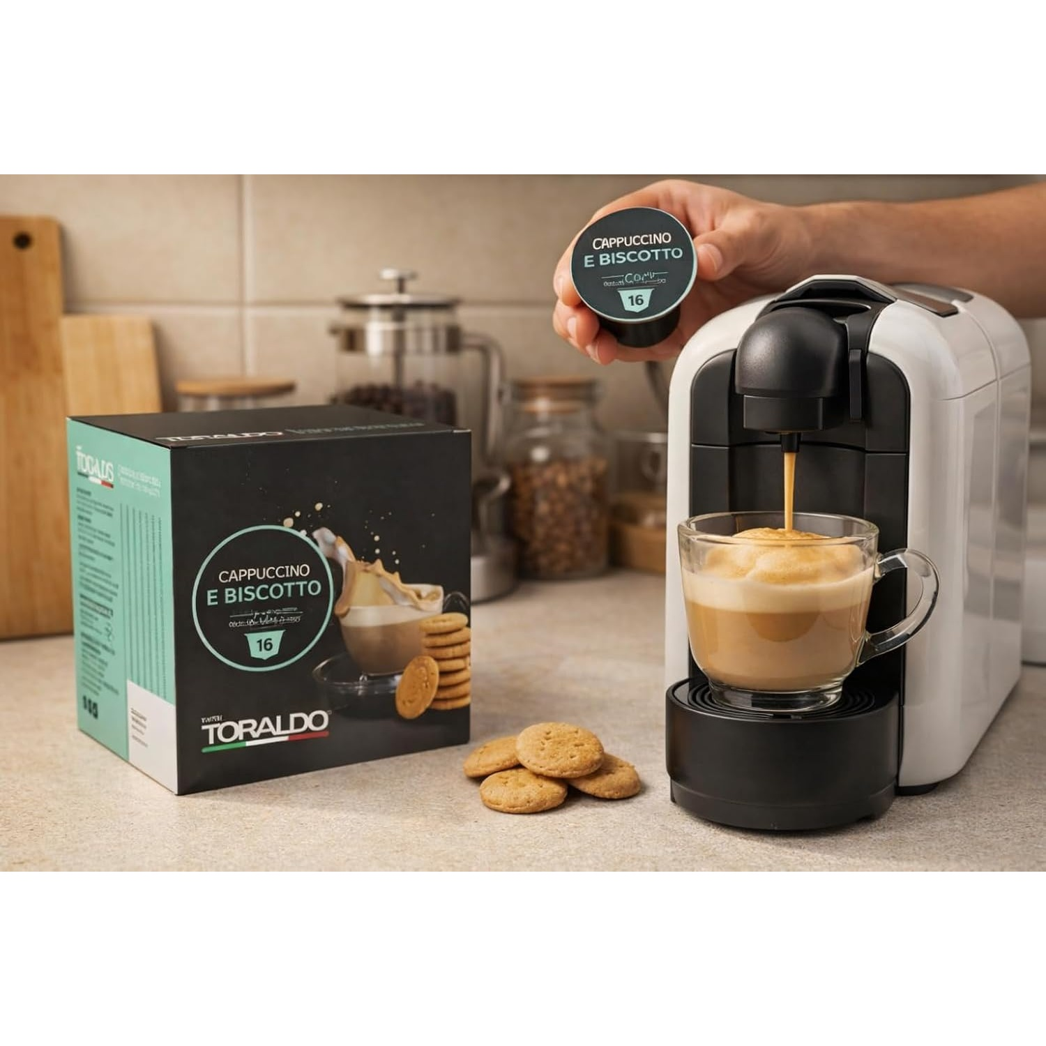 Una macchina da caffè bianca prepara un cappuccino in una tazza di vetro. Una capsula è tenuta.