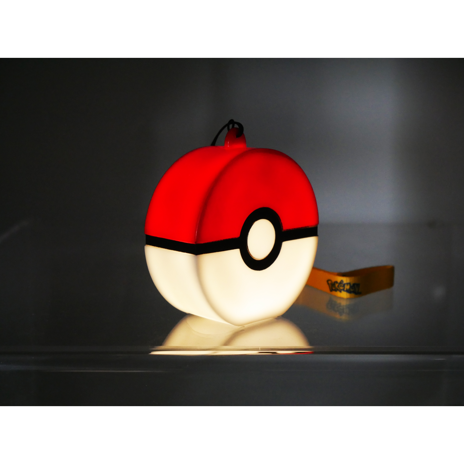Een gloeiende Poké bal op een donkere achtergrond met reflectie.