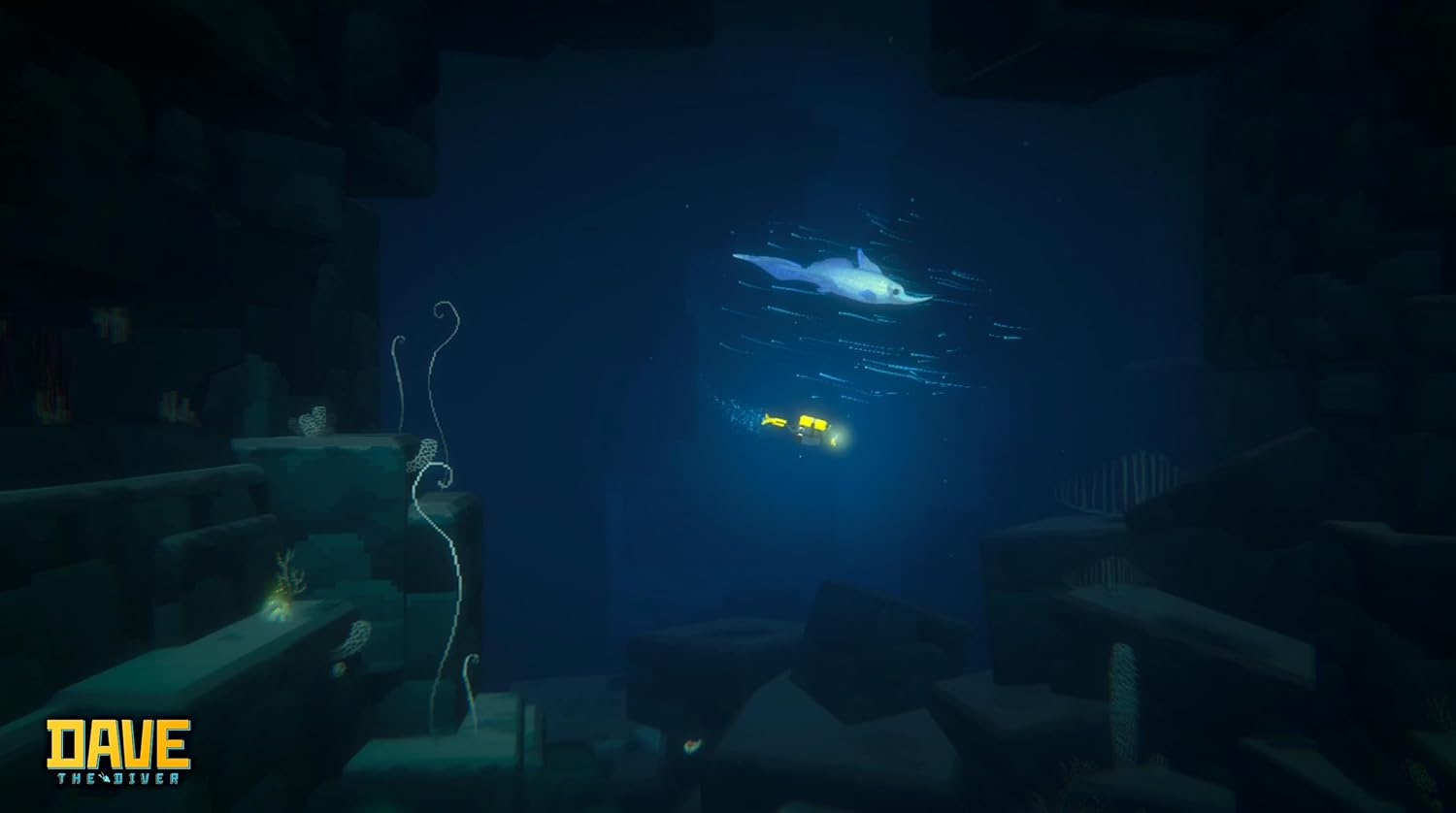 Ein Taucher in einem gelben U-Boot schwimmt unter einem Mantarochen im tiefblauen Meer.