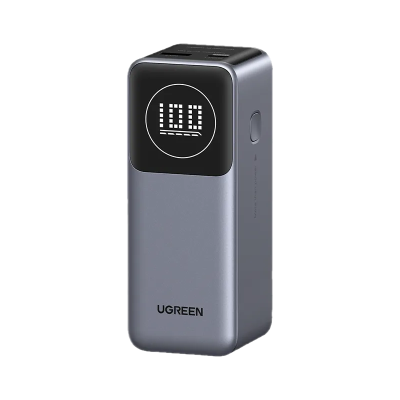 Power bank UGREEN grigio con display digitale che mostra 100%. Porte USB in alto.