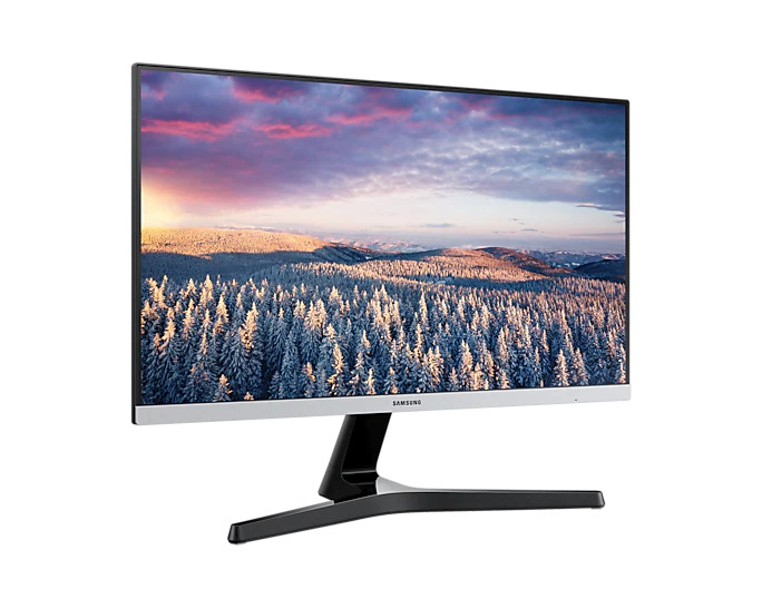 Monitor Samsung wyświetla ośnieżony krajobraz leśny z różowymi chmurami na niebie.