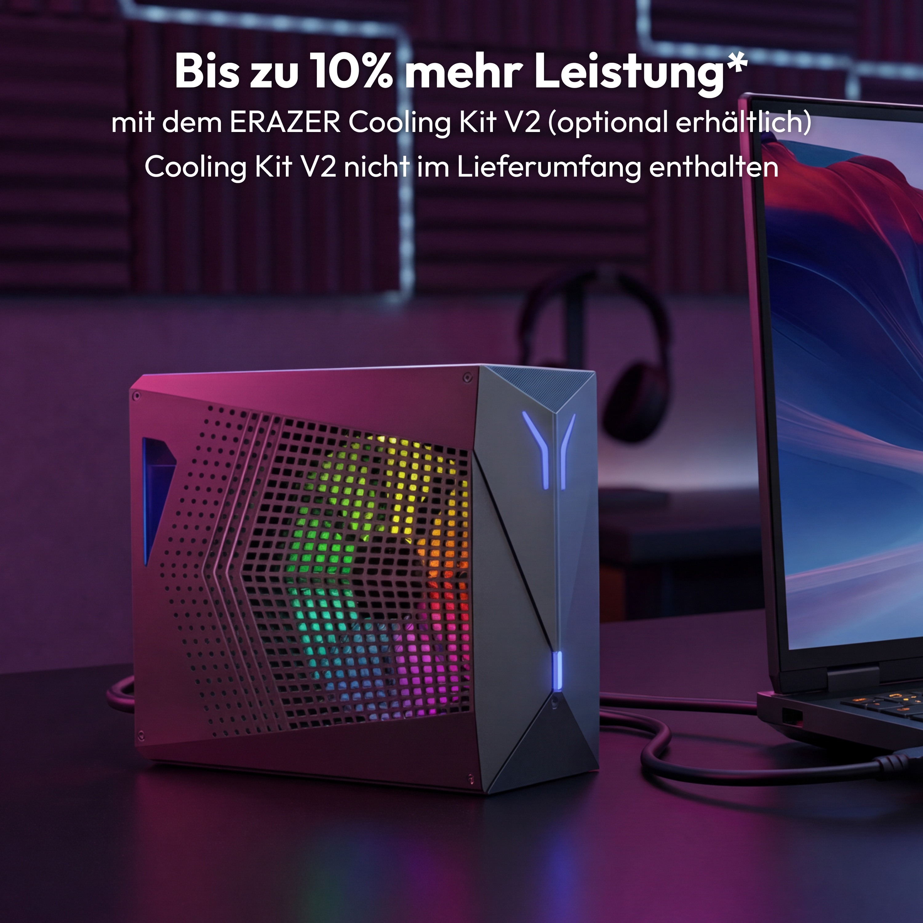Ein Gaming-PC mit RGB-Beleuchtung steht neben einem Laptop. Text auf Deutsch.