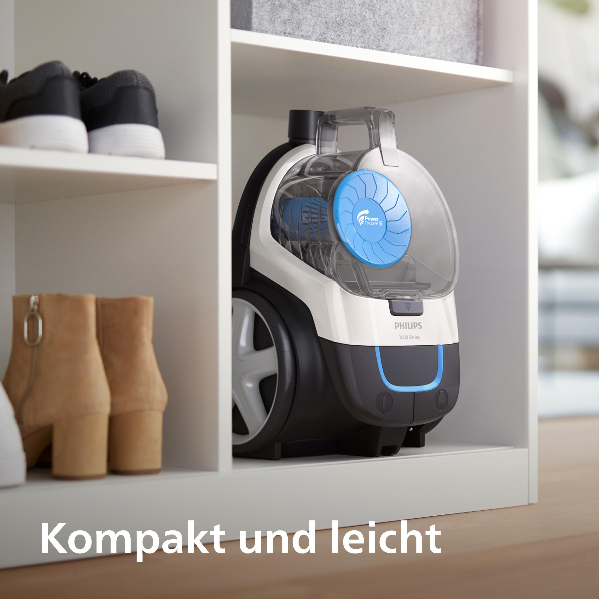 Ein weißer und schwarzer Philips Staubsauger mit blauem Detail, auf einem Regal.