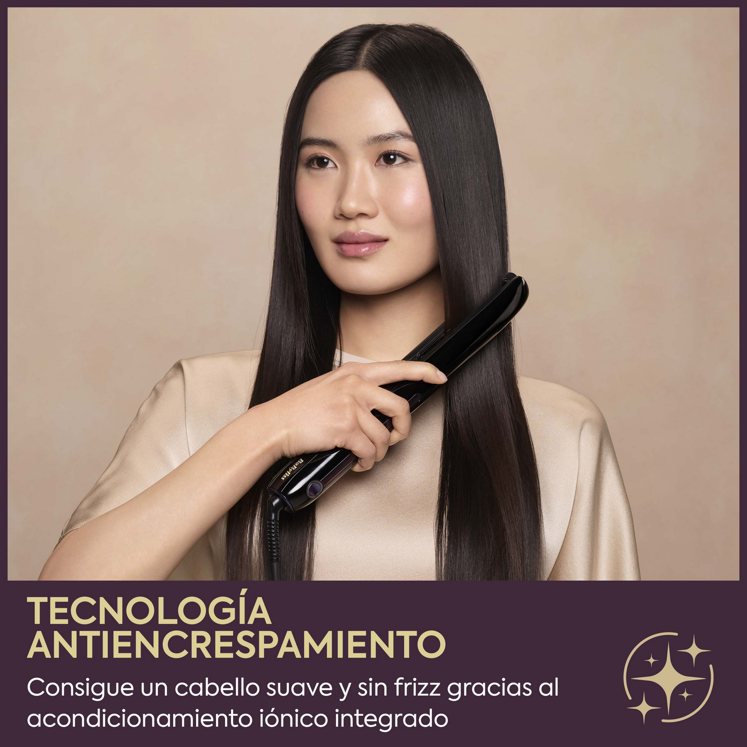 Mujer alisando su pelo largo y oscuro con una plancha negra sobre fondo crema.