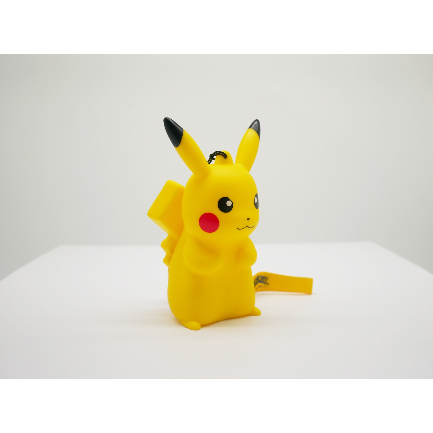 Gele Pikachu speelgoed met zwartpuntige oren en rode wangen, op witte ondergrond.