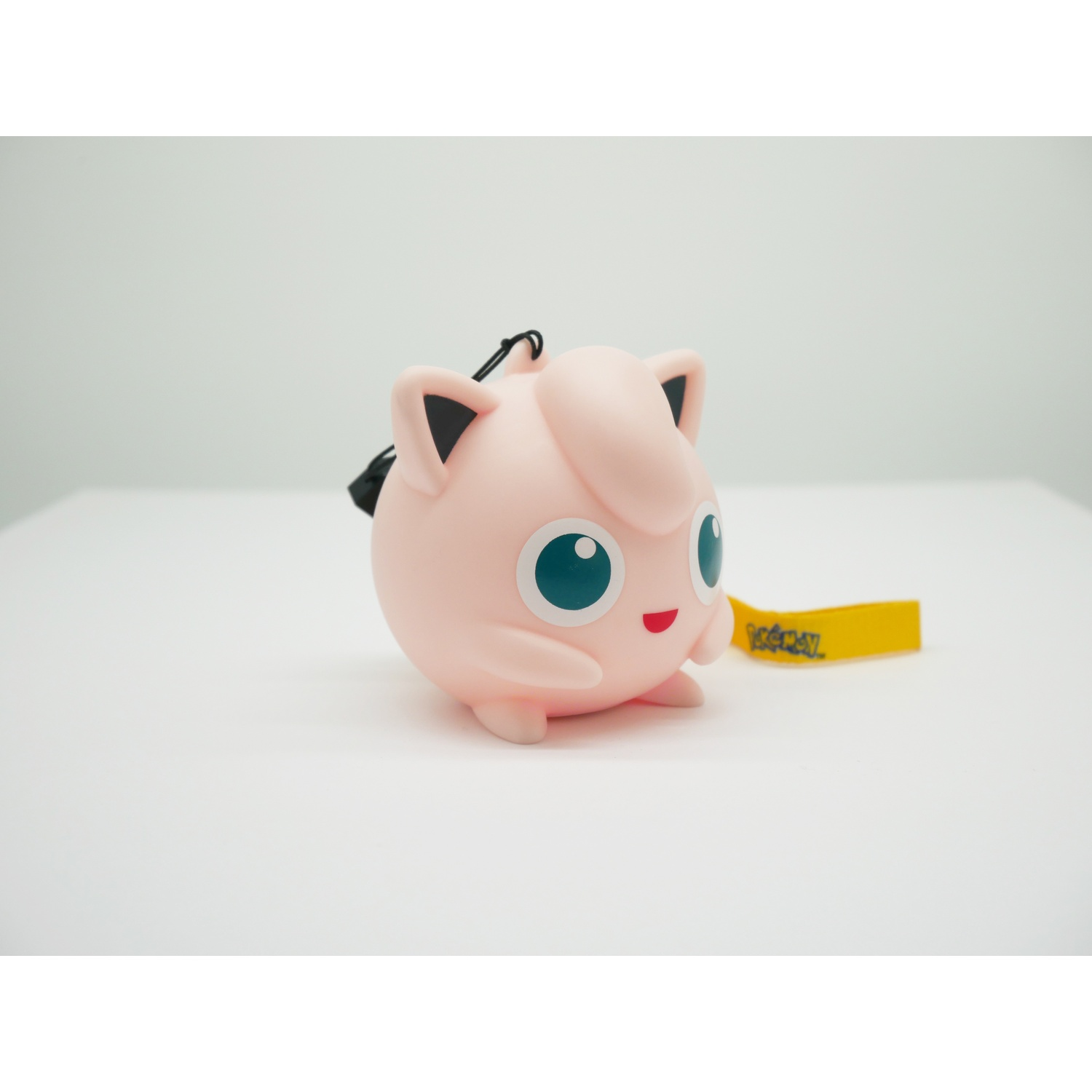 Een roze Jigglypuff figuur met blauwe ogen en een geel Pokémon logo label.