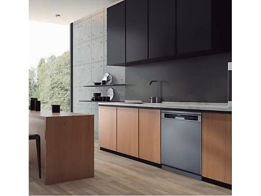 Cocina moderna con gabinetes de madera, lavavajillas y pared de concreto.