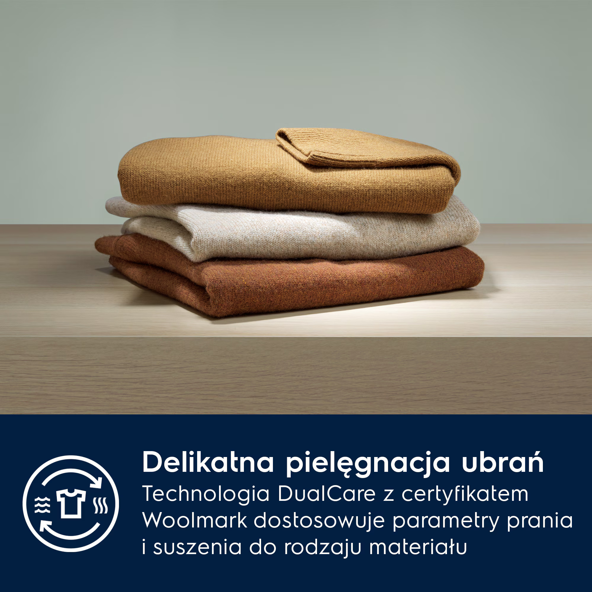 Stos swetrów w kolorach brązowym, beżowym i rudym na drewnianej powierzchni.