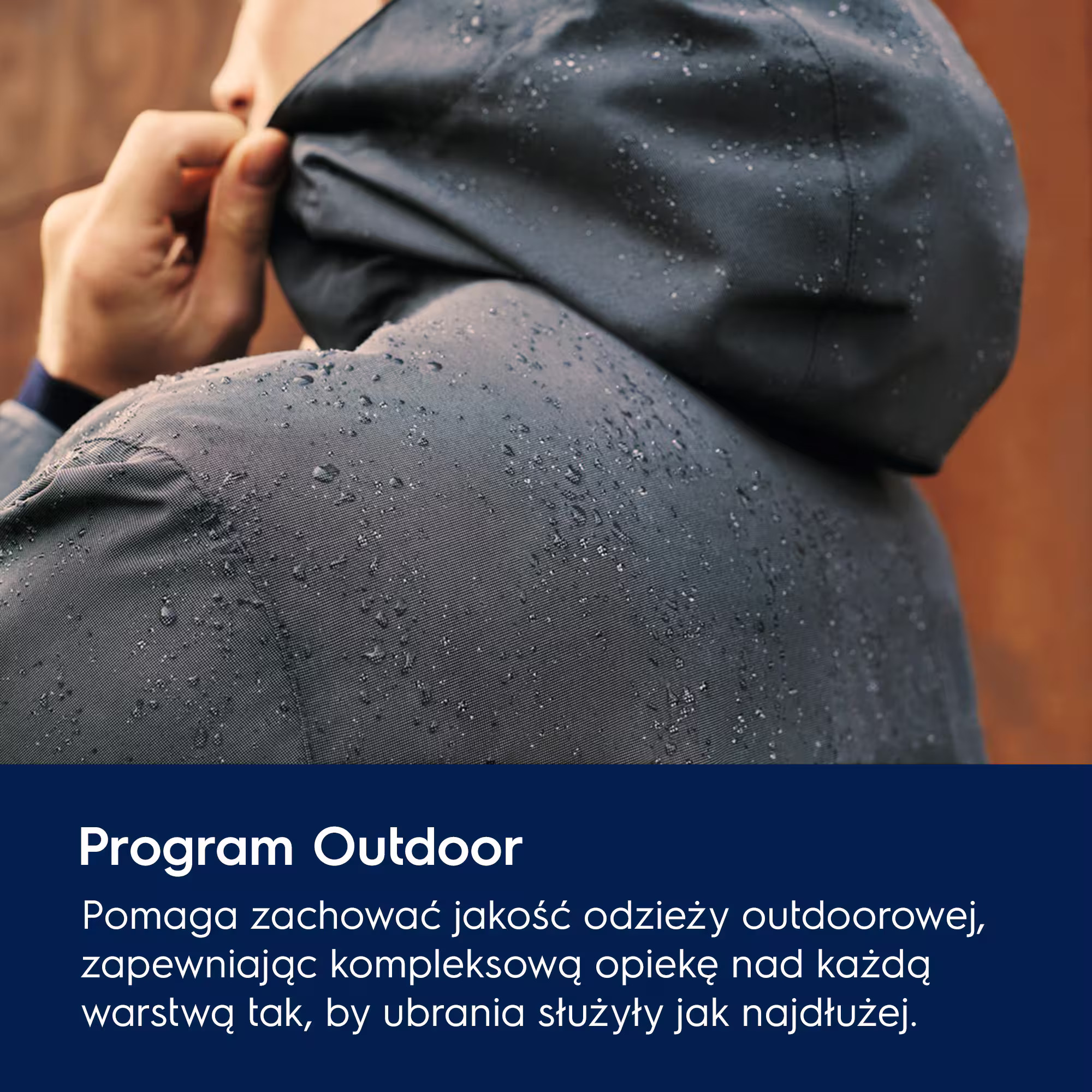 Osoba naciągająca kaptur ciemnej, mokrej kurtki outdoorowej.