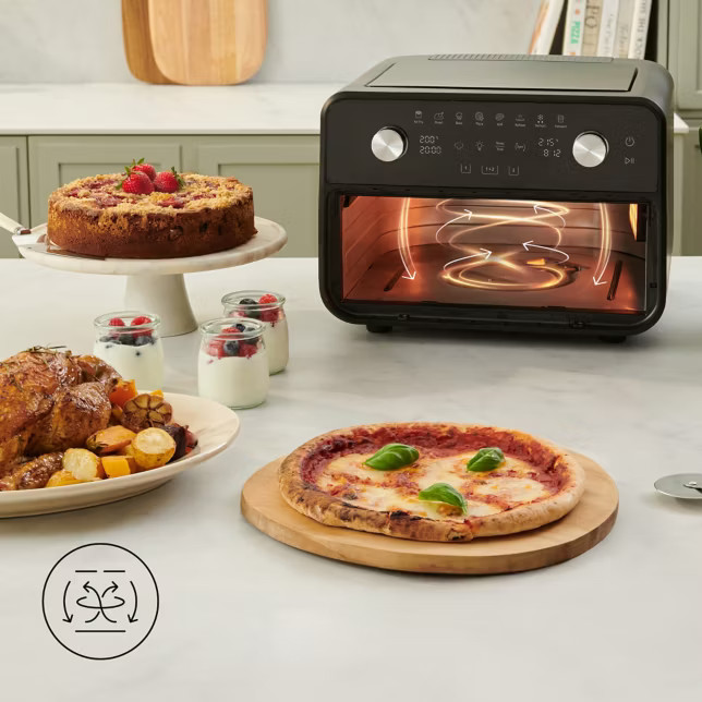 Czarna frytkownica beztłuszczowa z jedzeniem: pieczony kurczak, pizza, ciasto, jogurt.