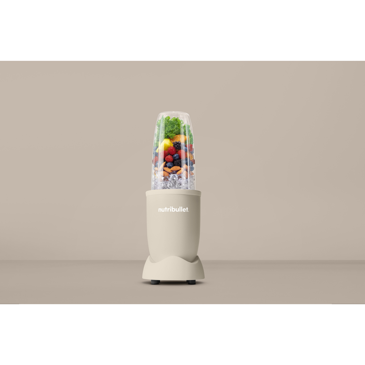 Un frullatore Nutribullet beige con frutta e cubetti di ghiaccio.