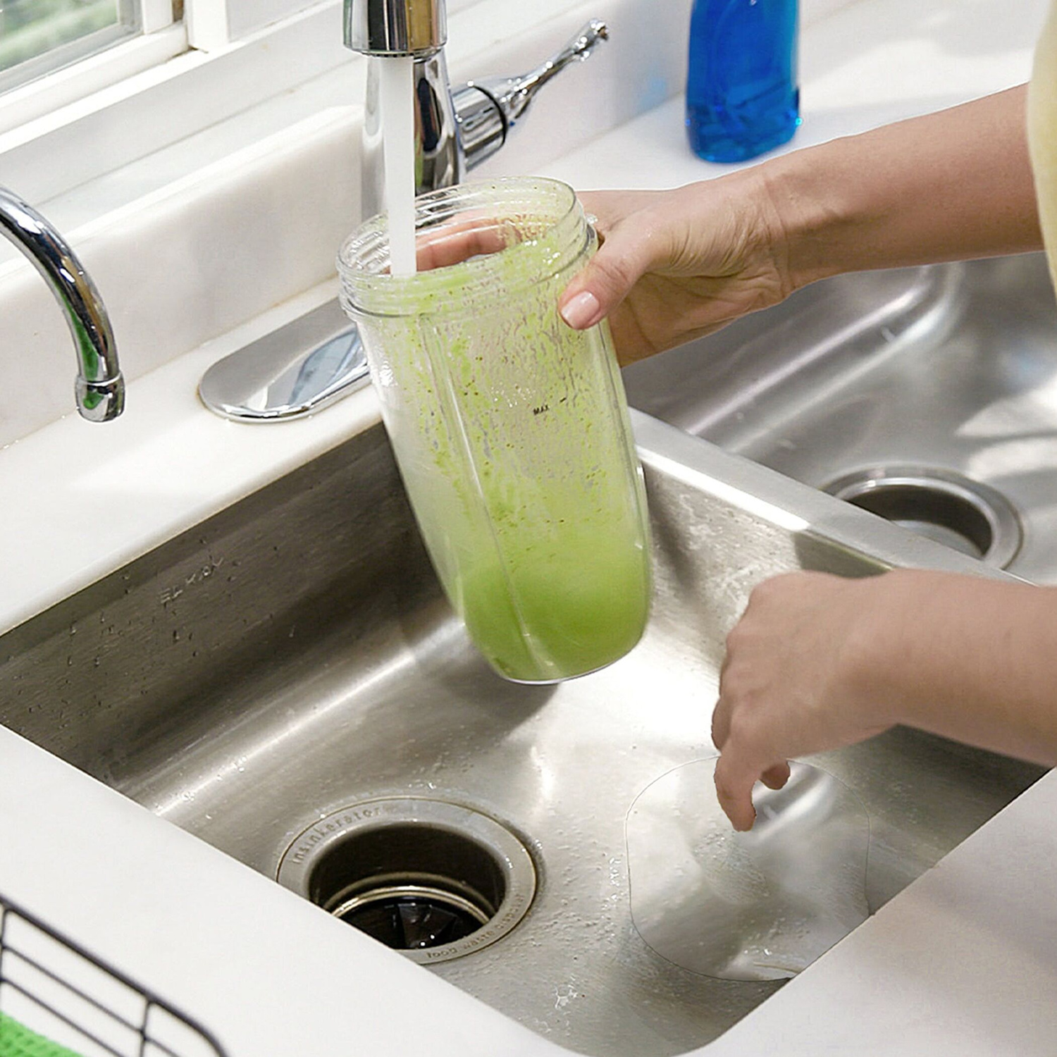 Frullato verde sciacquato sotto acqua corrente nel lavello.