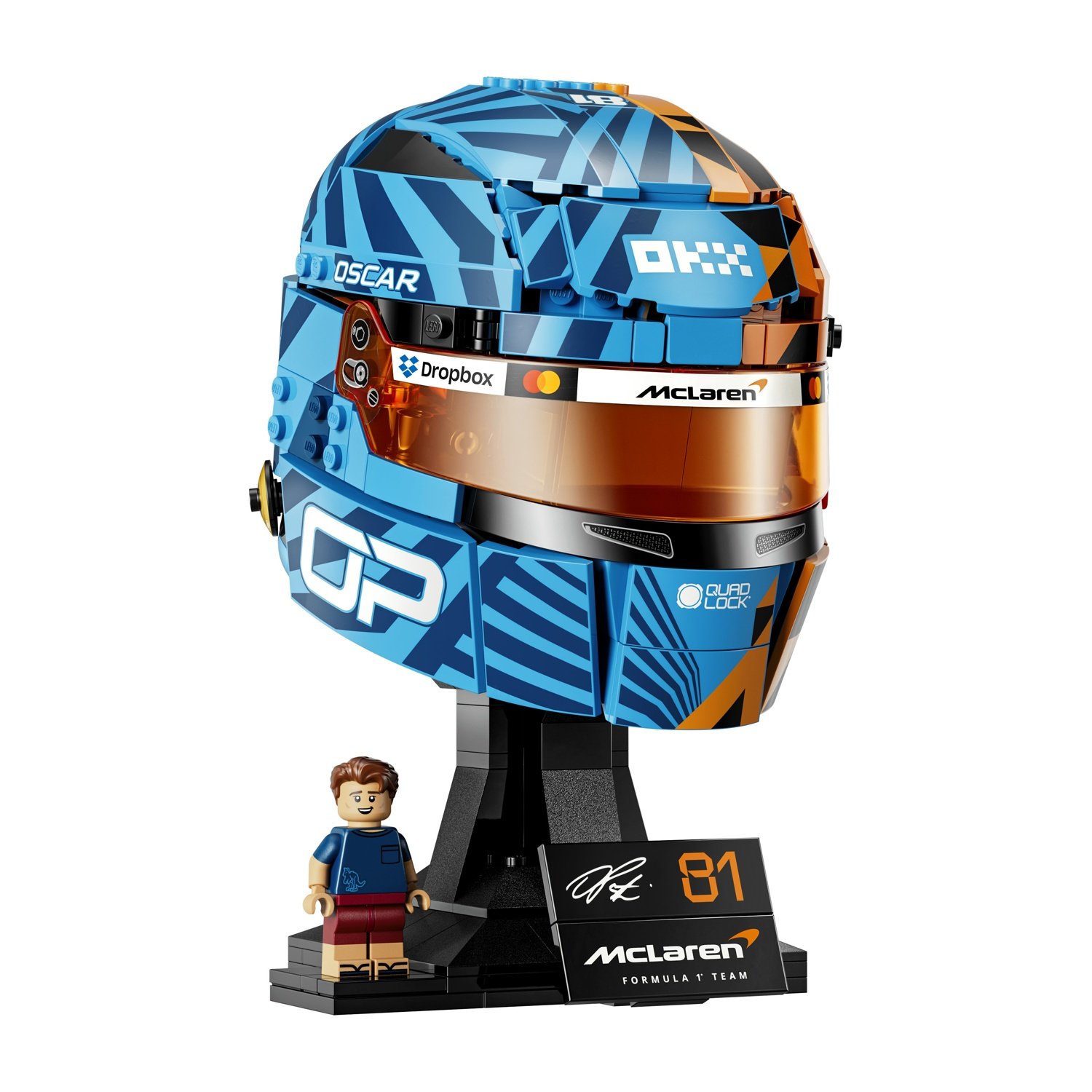 Un modello Lego del casco di Oscar Piastri su un supporto con minifigure.