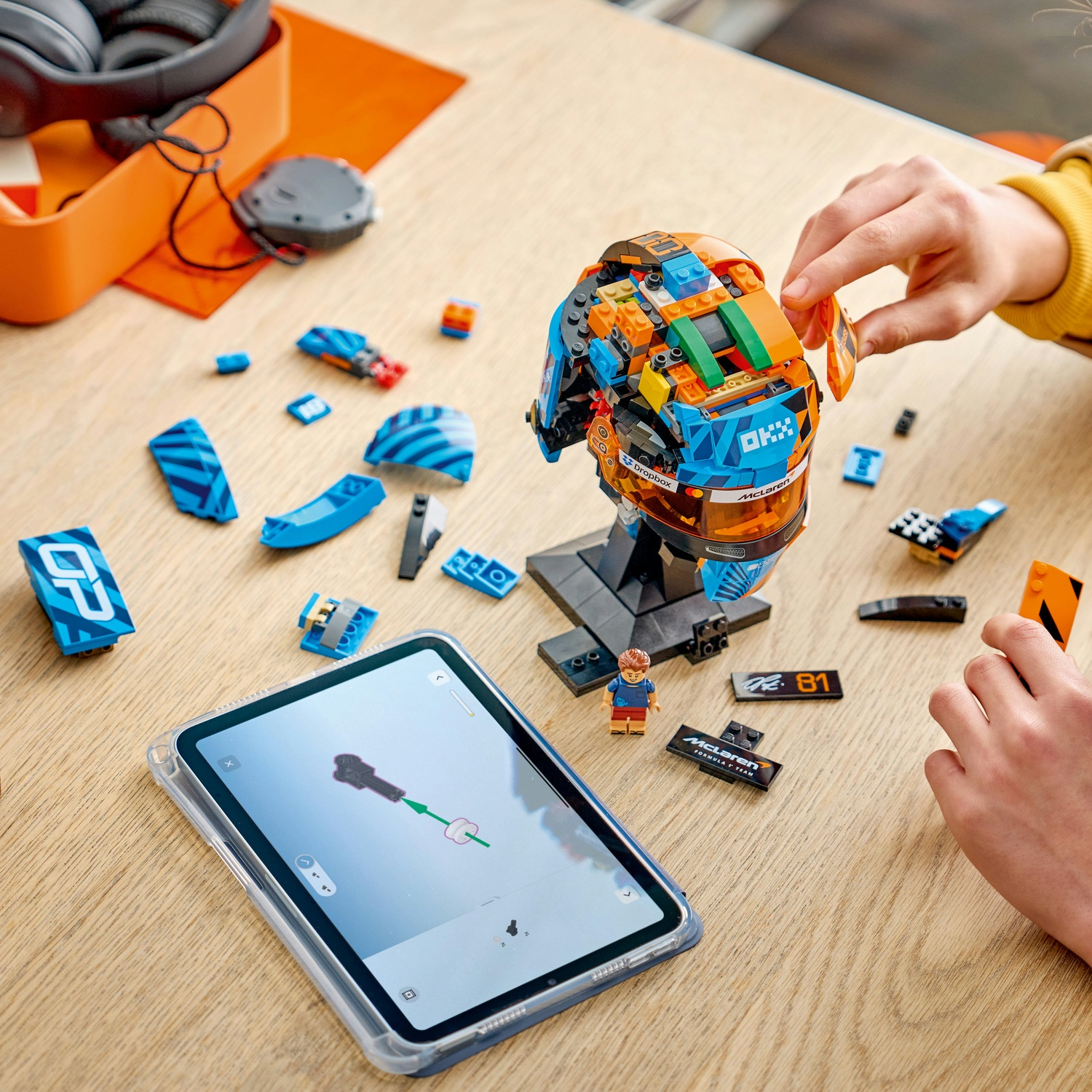 Un bambino costruisce un casco Lego con un tablet che mostra le istruzioni.