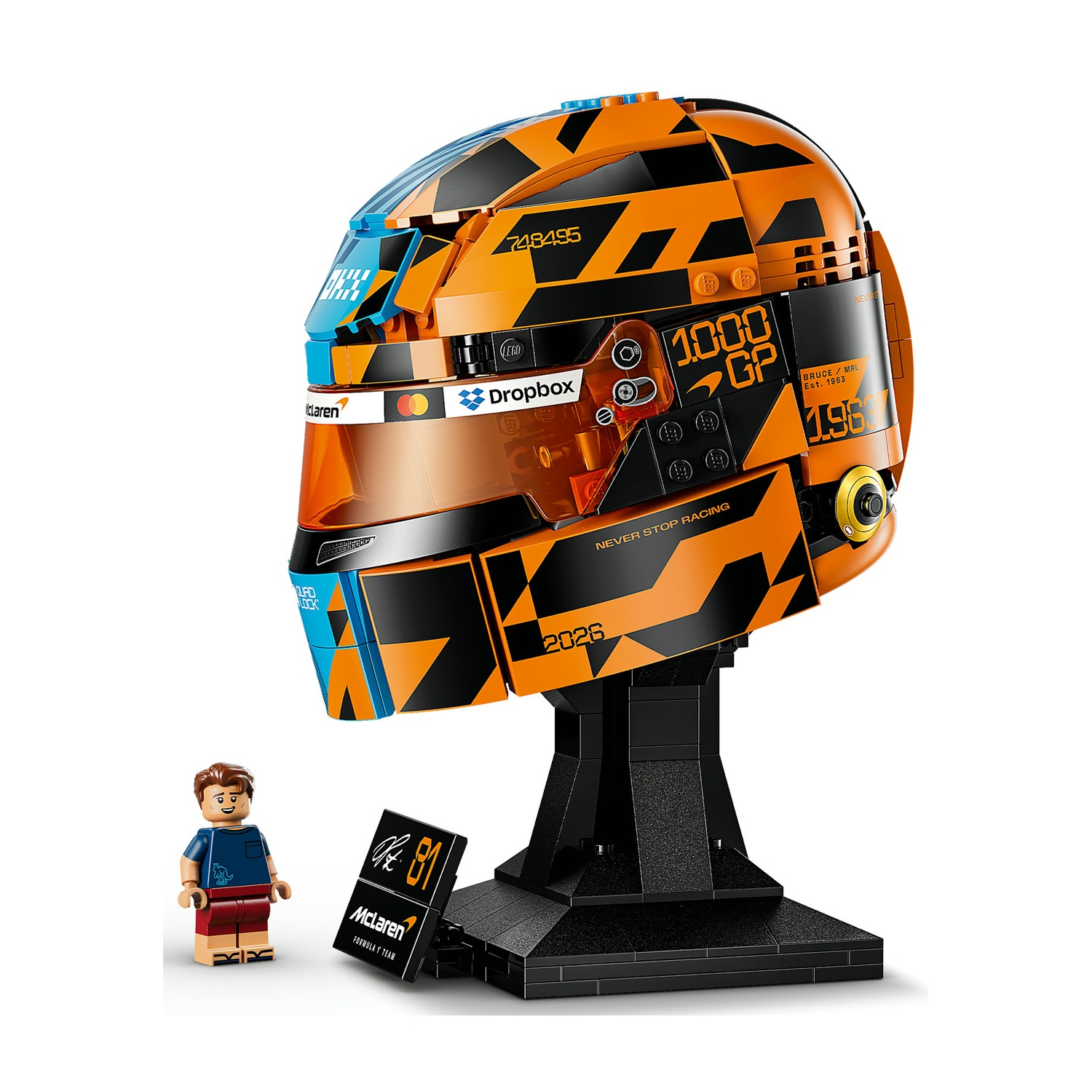 Un casco Lego arancione e nero con supporto e minifigure.