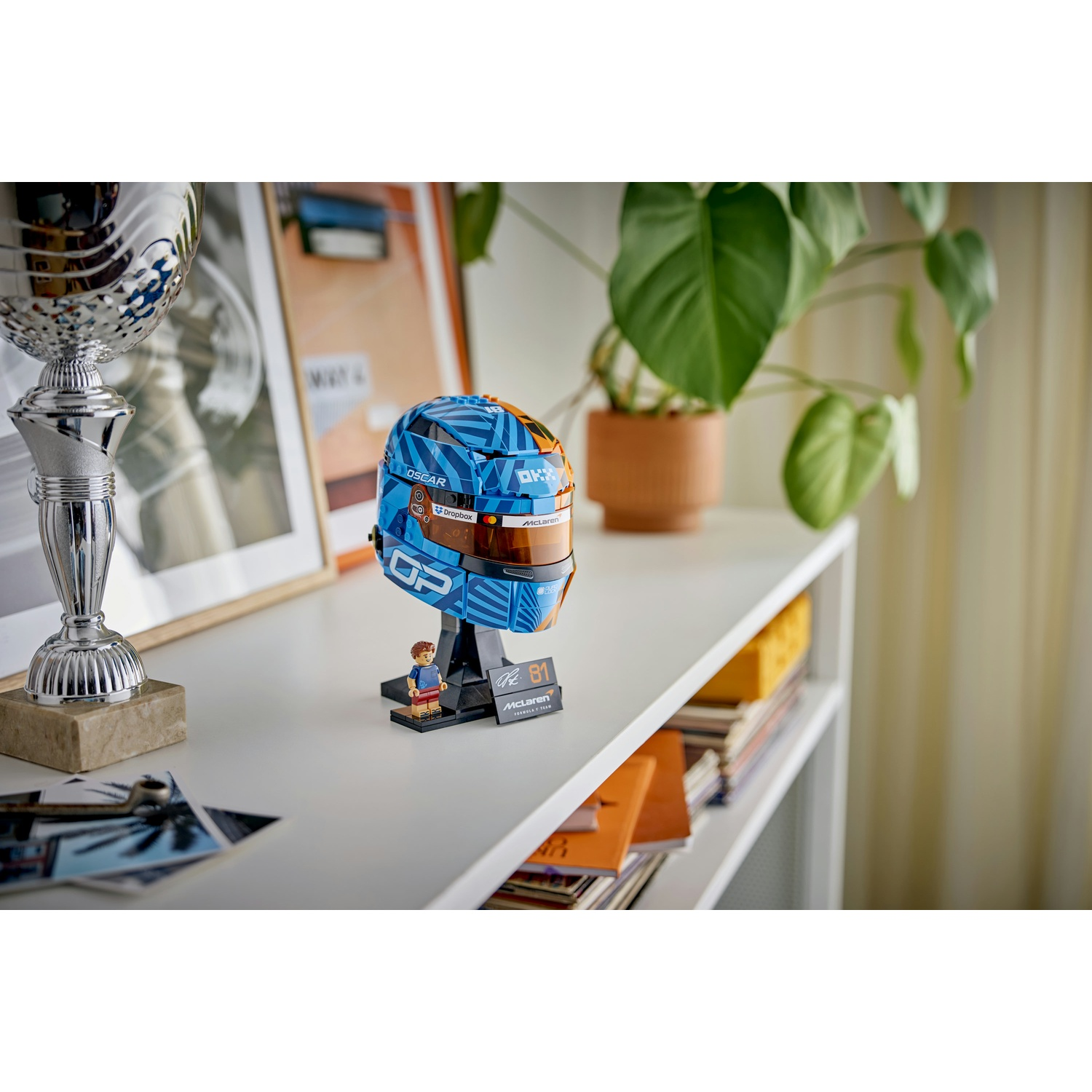 Un casco Lego blu con accenti arancioni si trova su uno scaffale.