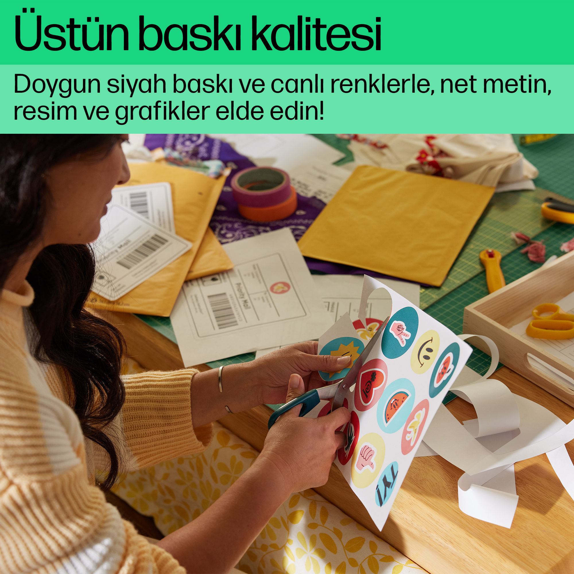 Bir kadın masadaki zarflarla çıkartmalar kesiyor.