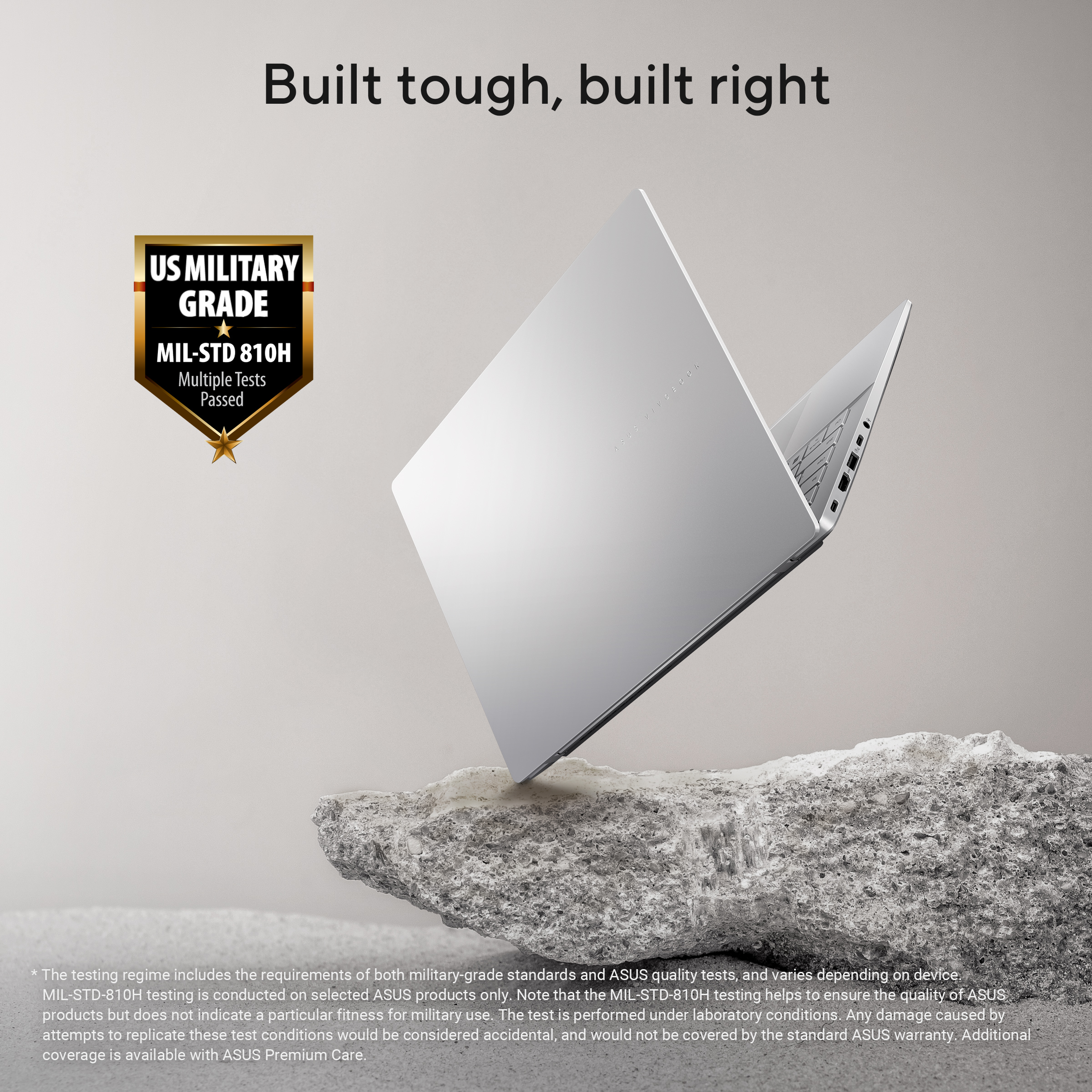 Een zilveren ASUS Vivobook laptop rust op een rots. VS Militaire Kwaliteit gecertificeerd.