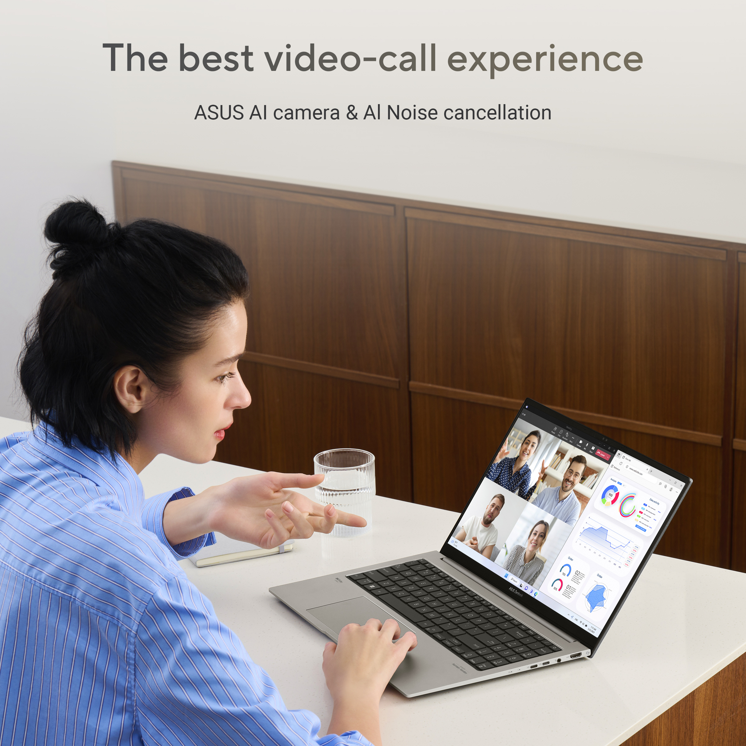 Een vrouw met een knot in een gestreept shirt is aan het videobellen op een laptop.