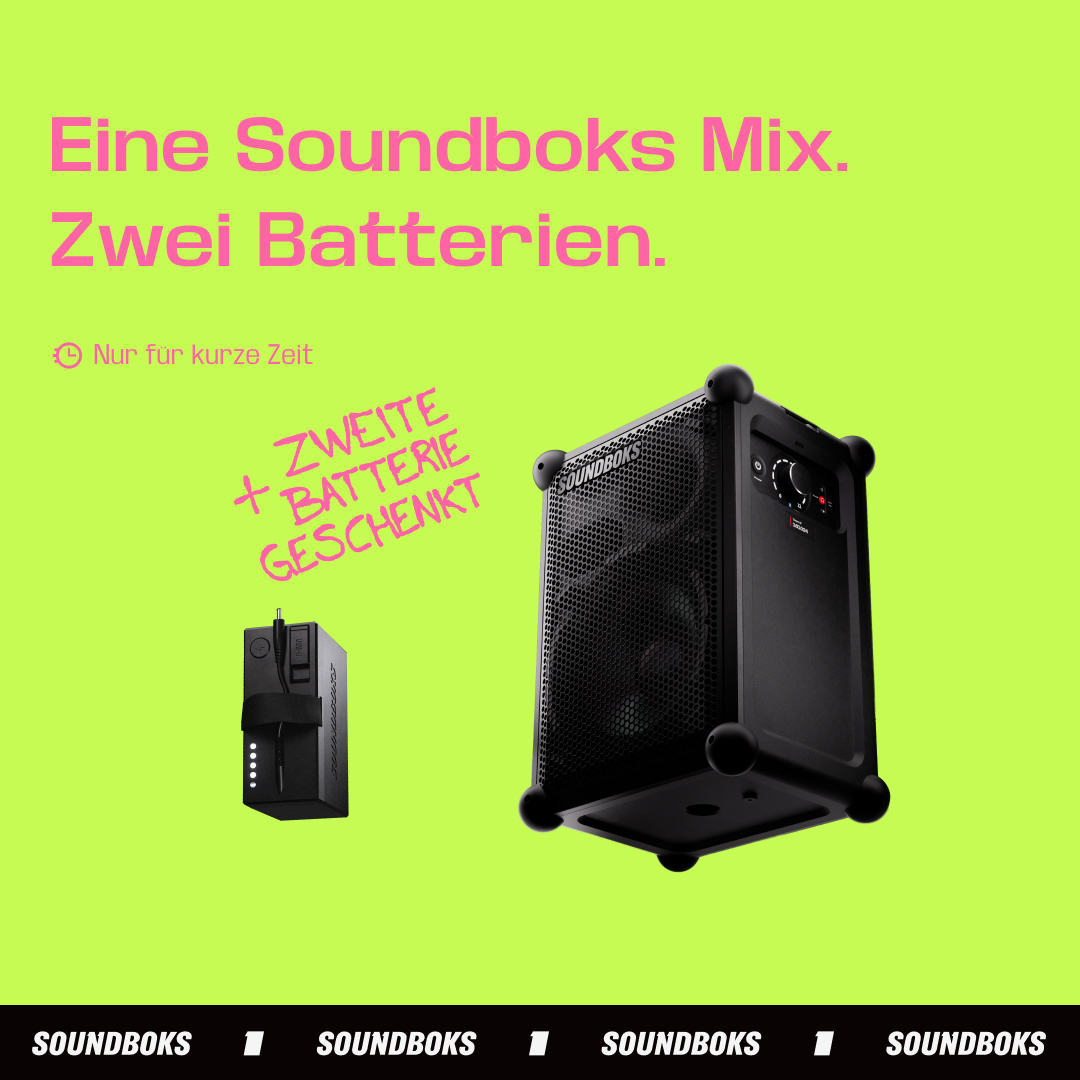 Ein schwarzer Lautsprecher und eine Batterie auf grünem Hintergrund.