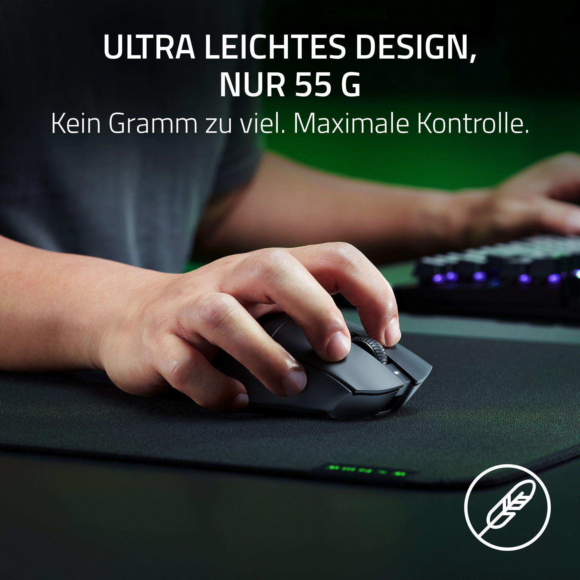 Eine Hand bedient eine leichte schwarze Maus auf einer schwarzen Matte. Tastatur im Hintergrund.