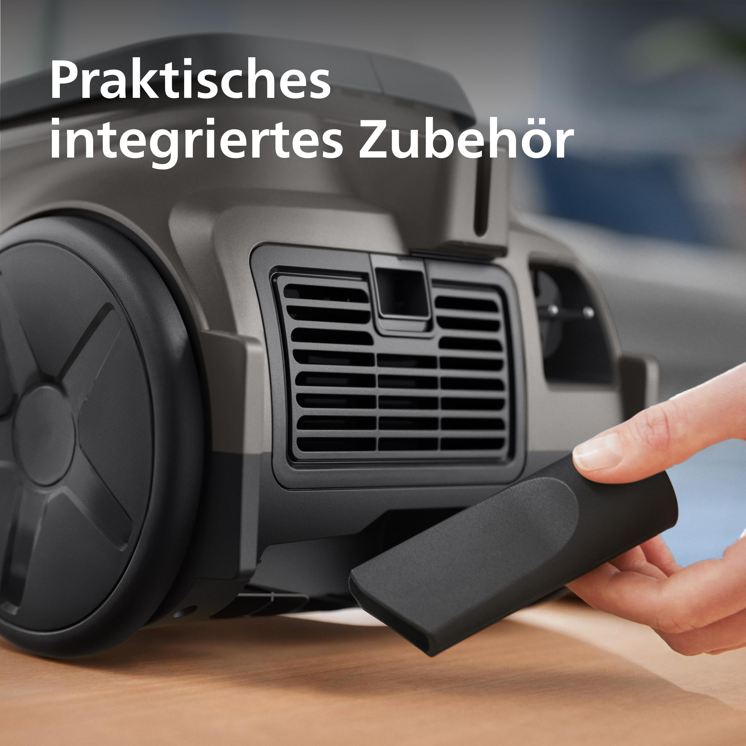 Ein schwarzer Staubsauger mit Zubehör in der Hand. Praktisches Zubehör.