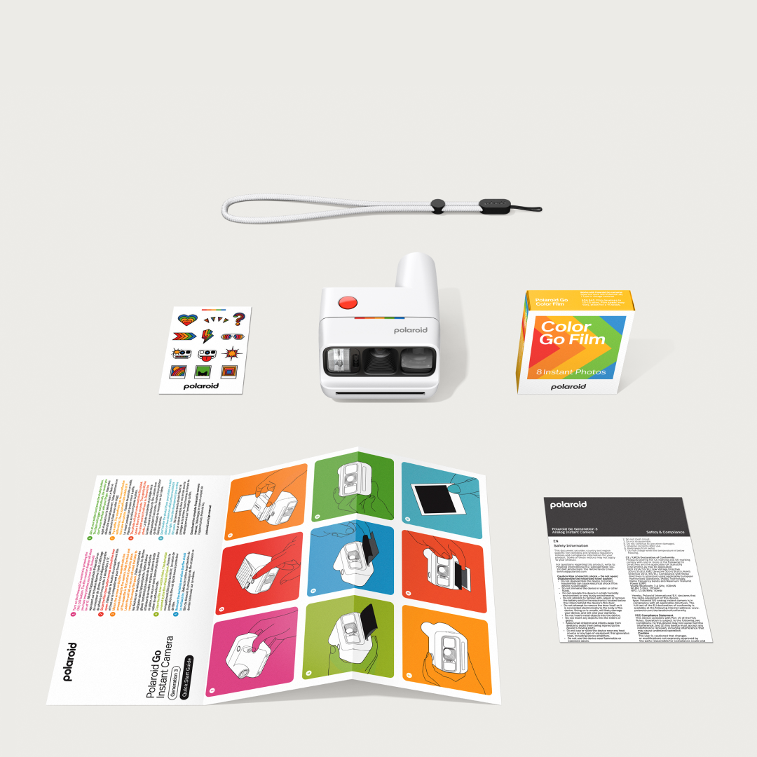 Fehér Polaroid Go kamera, film doboz, matricák, szíj és kézikönyvek.