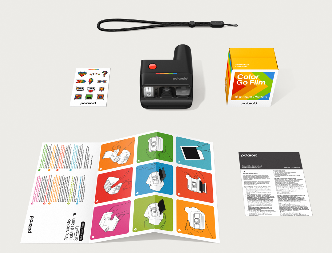 Polaroid Go kamera, film doboz, matricák, szíj és kézikönyvek világosszürke háttéren.