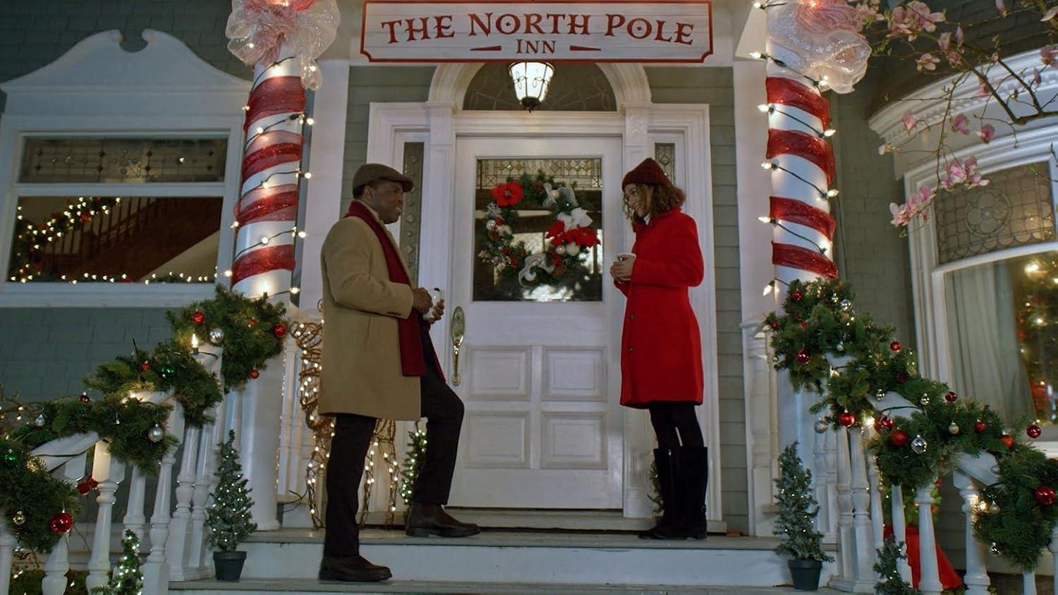 Zwei Personen stehen vor dem Eingang des North Pole Inn mit Weihnachtsdekorationen.