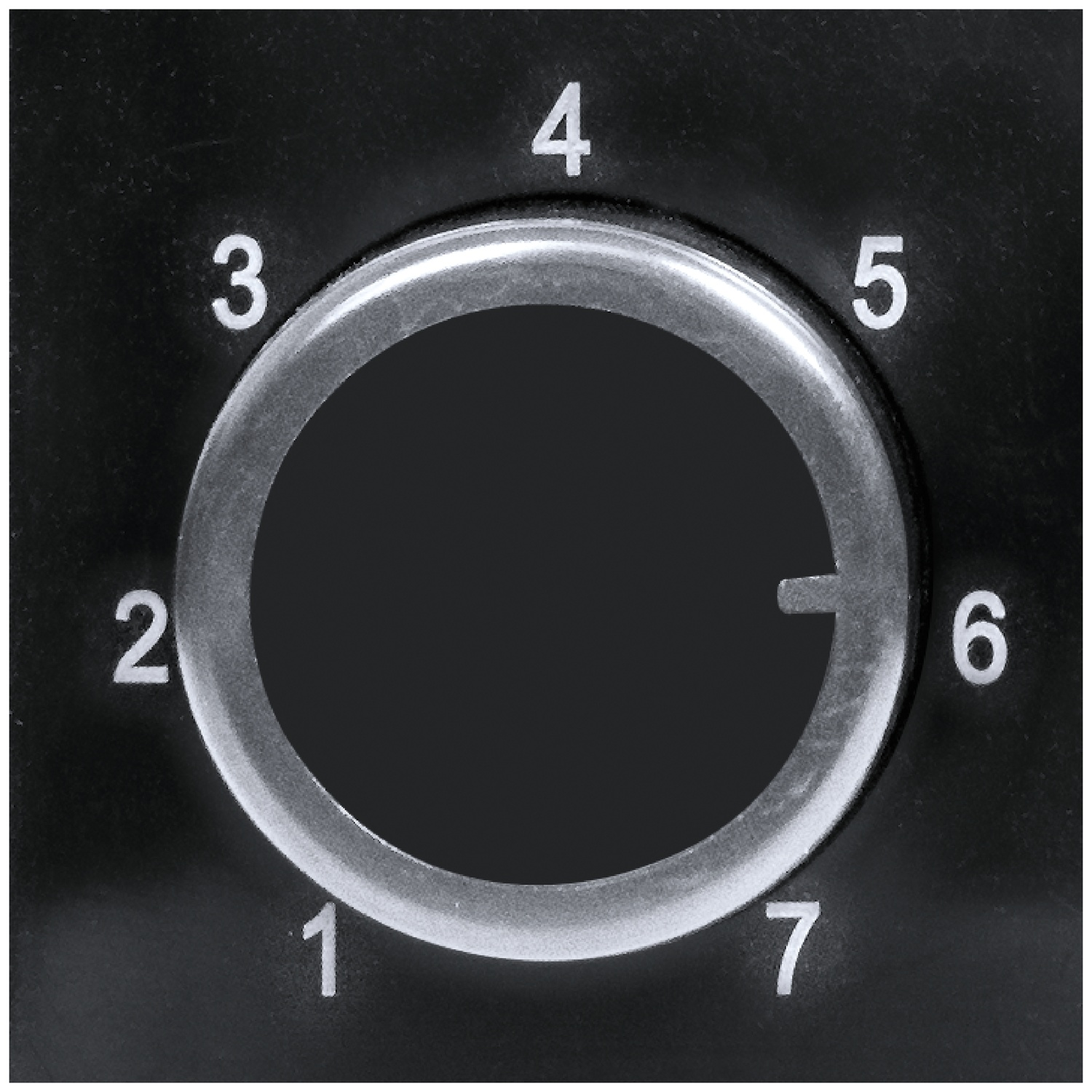 Un cadran noir avec les numéros 1 à 7 et un repère à 6.