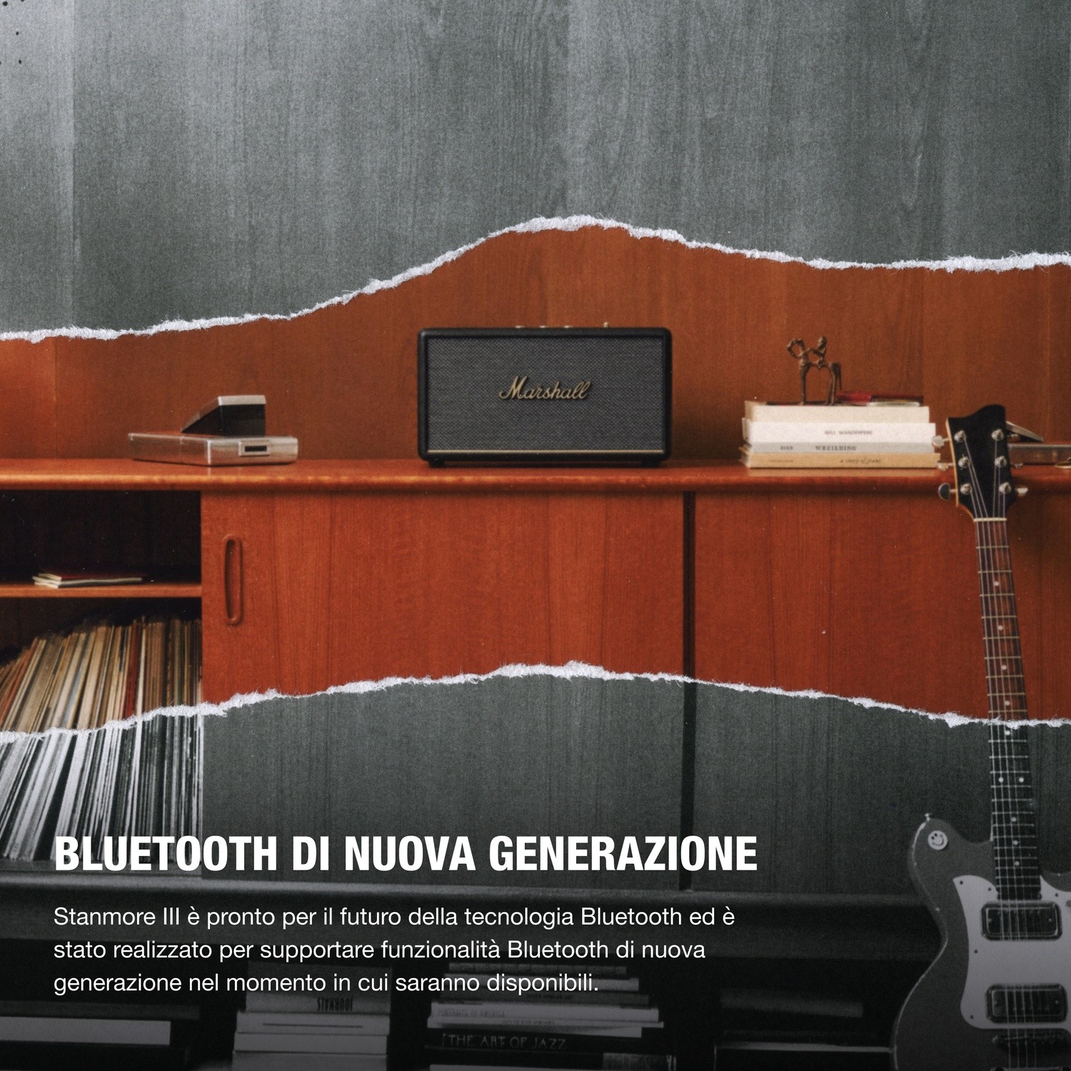 Altoparlante Marshall su mobile in legno con chitarra e libri.