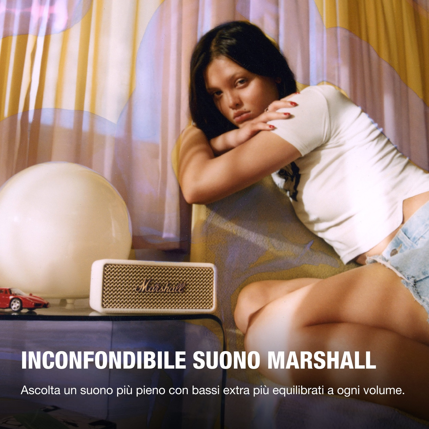 Una giovane donna è sdraiata su un divano accanto a un altoparlante Marshall.
