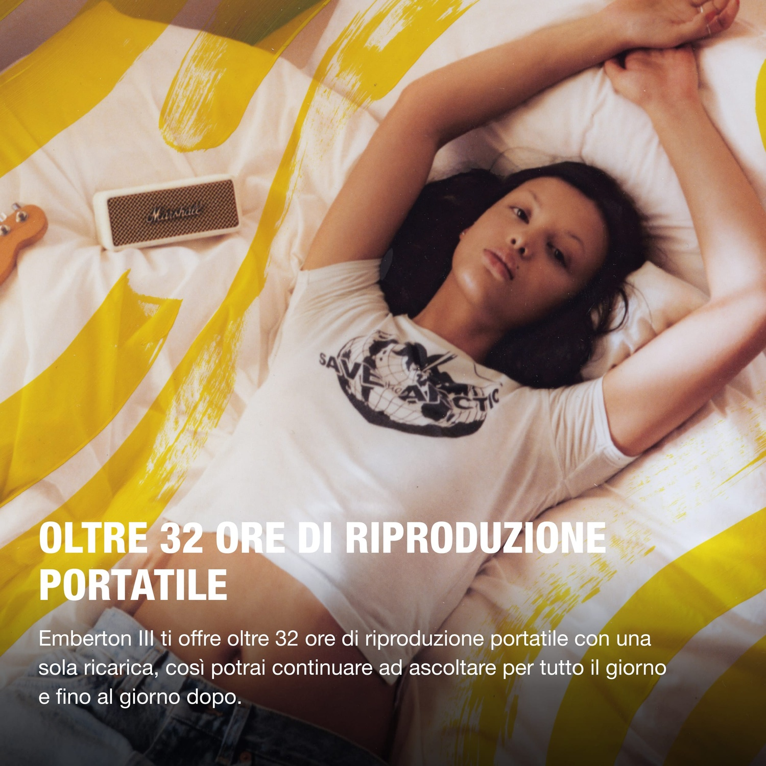 Una donna giace su un letto con pennellate gialle, accanto a un altoparlante Marshall.