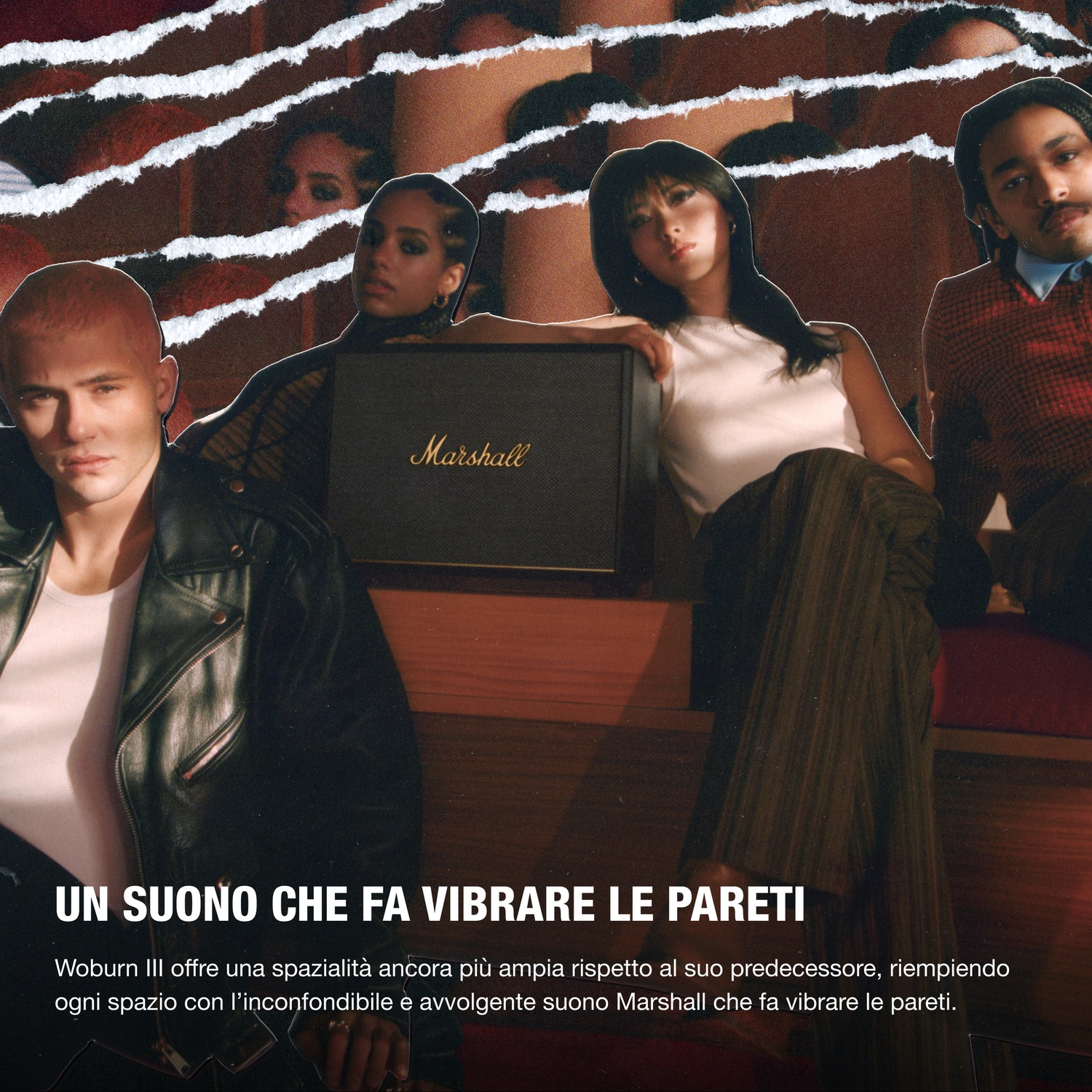 Quattro persone posano attorno a uno speaker Marshall. Un uomo in giacca di pelle è in primo piano.