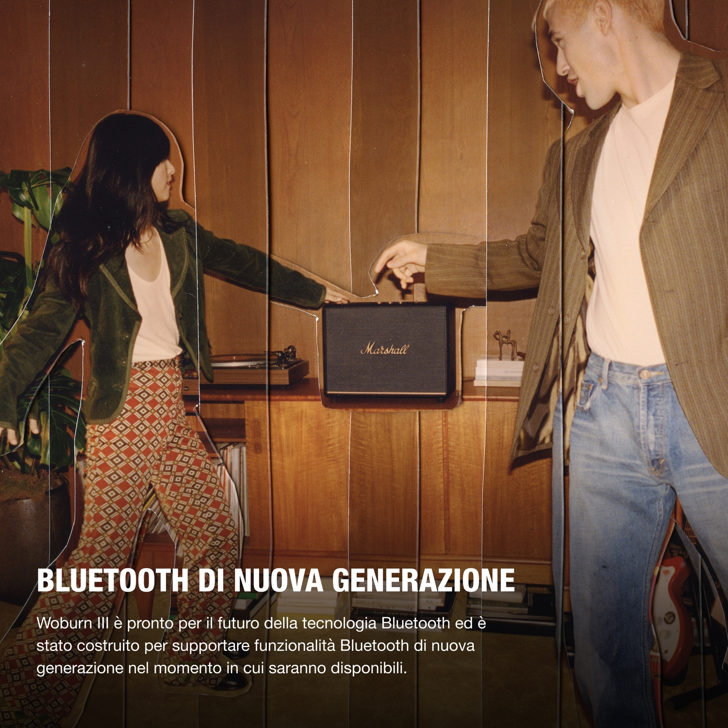 Due persone davanti a uno speaker Marshall in una stanza con pannelli di legno.