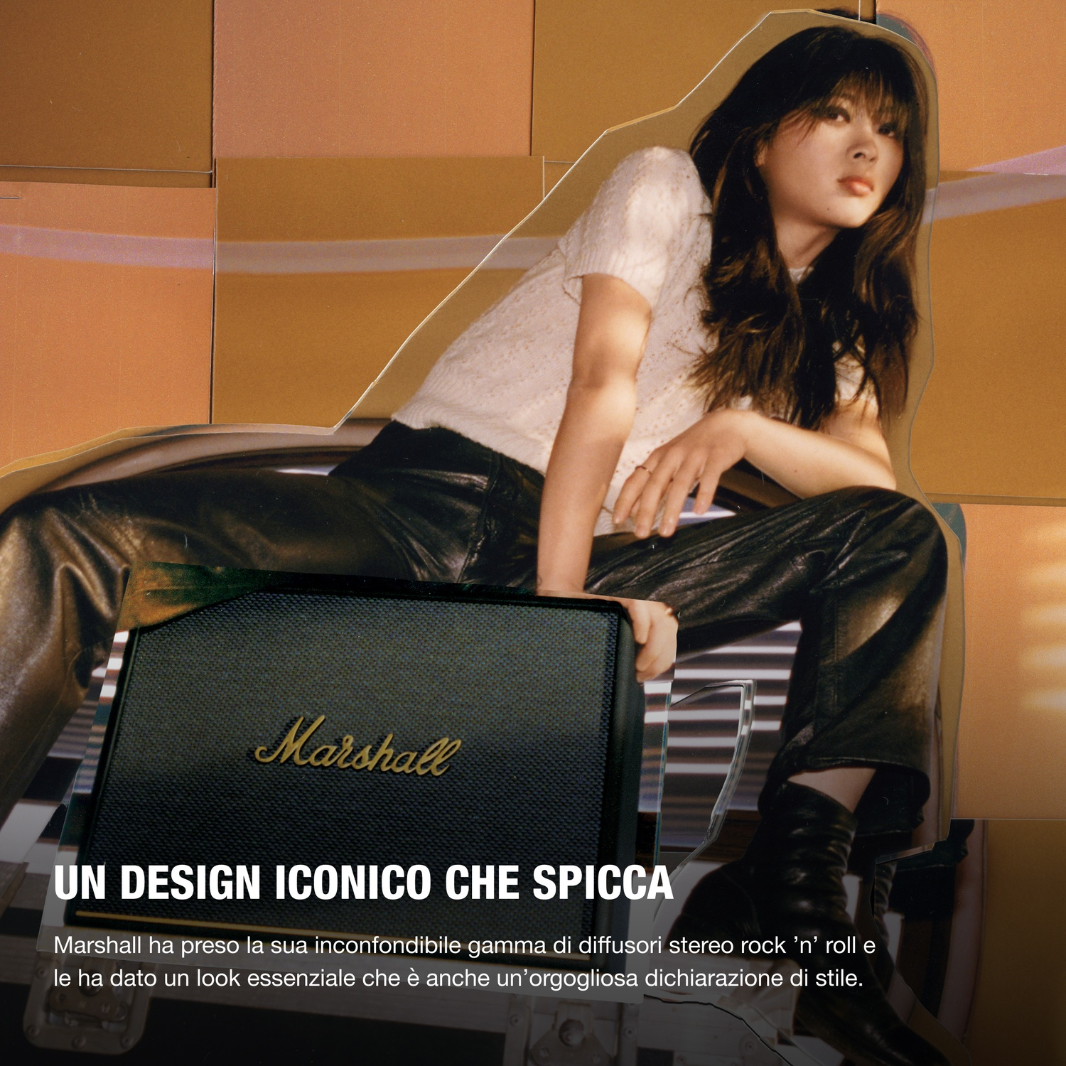 Donna con lunghi capelli scuri seduta vicino a uno speaker Marshall su sfondo dorato.