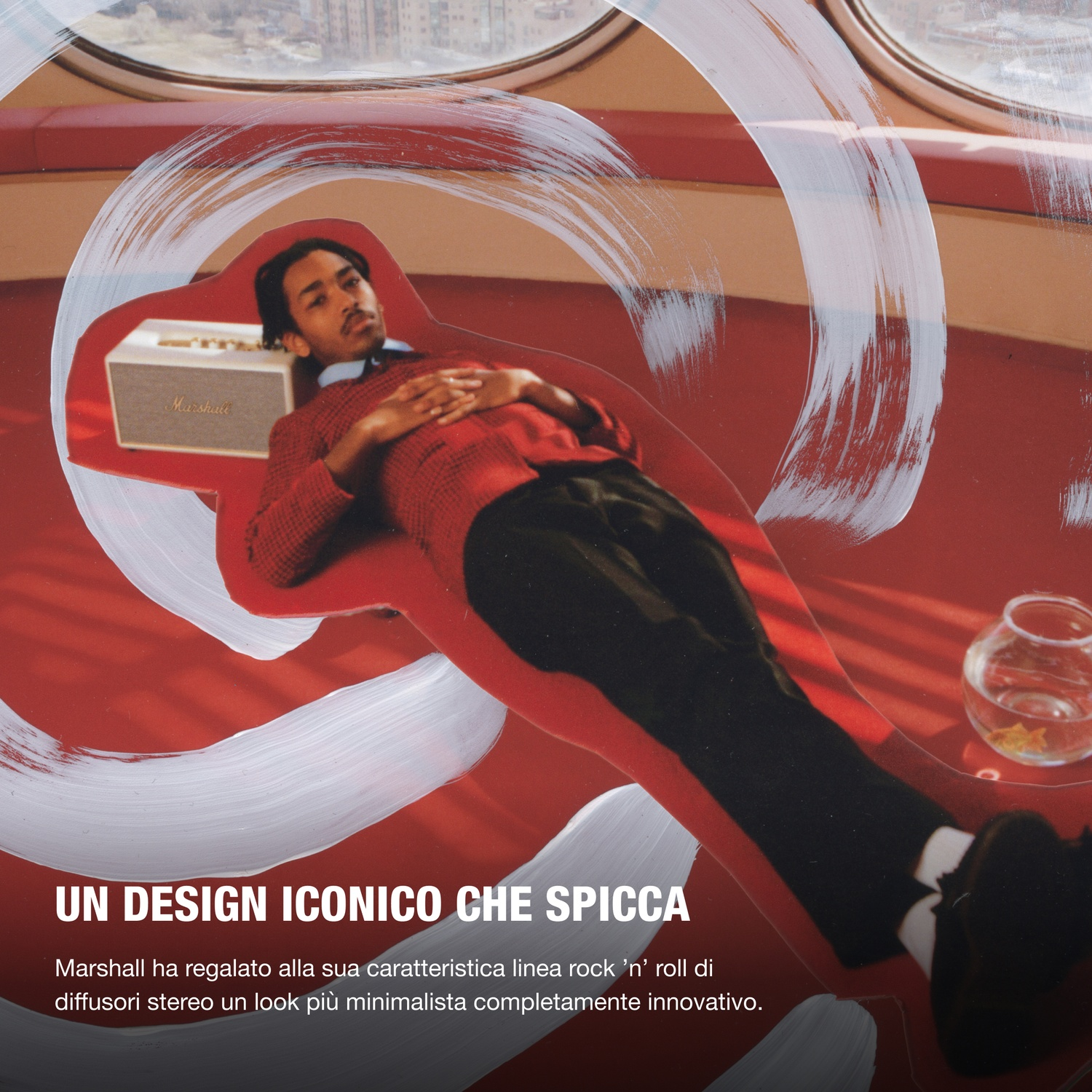 Uomo sdraiato su divano rosso vicino a speaker Marshall, davanti a finestra.