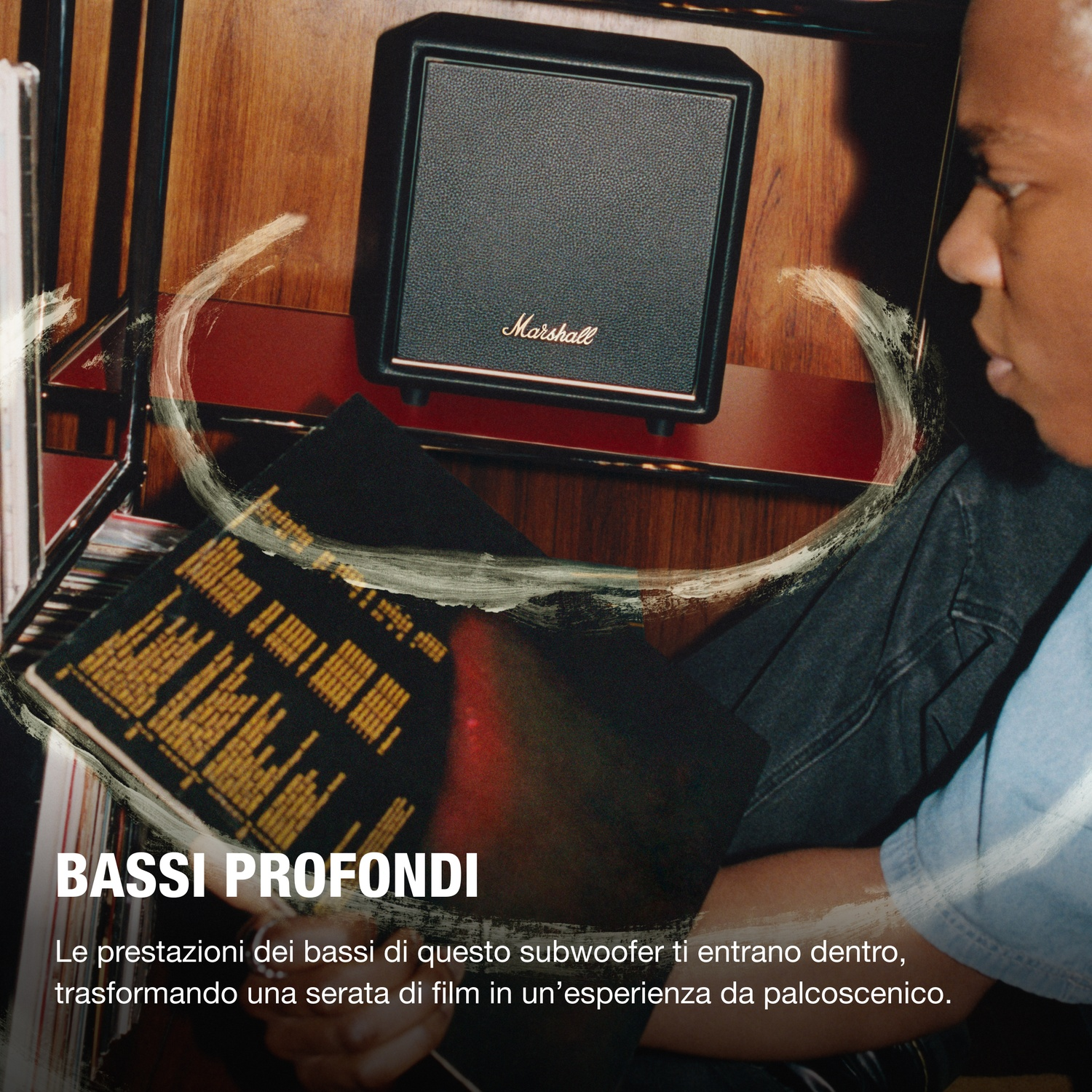 Un uomo guarda un altoparlante Marshall accanto a dischi in vinile.