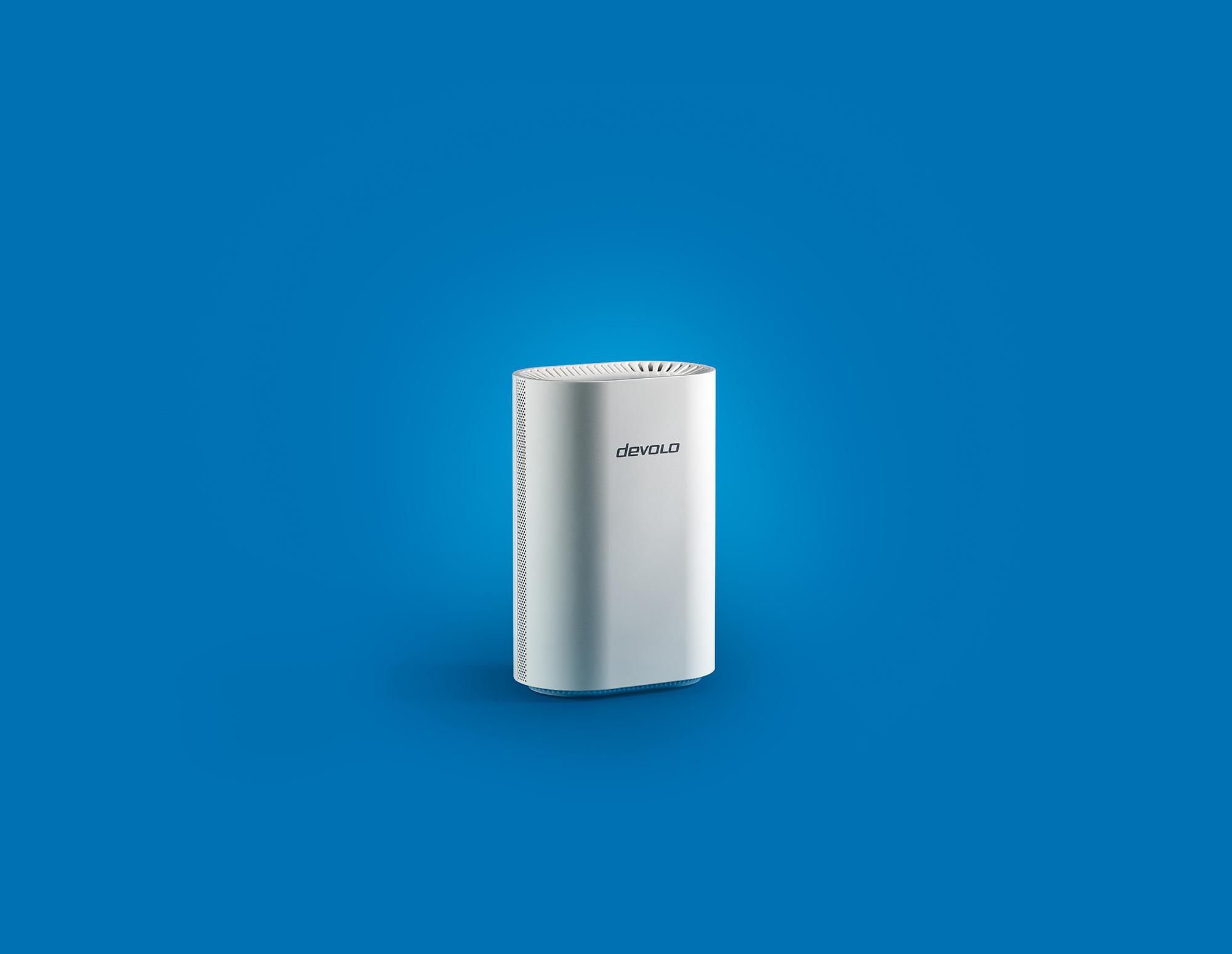 Ein weißer Devolo-Router steht vor einem blauen Hintergrund.