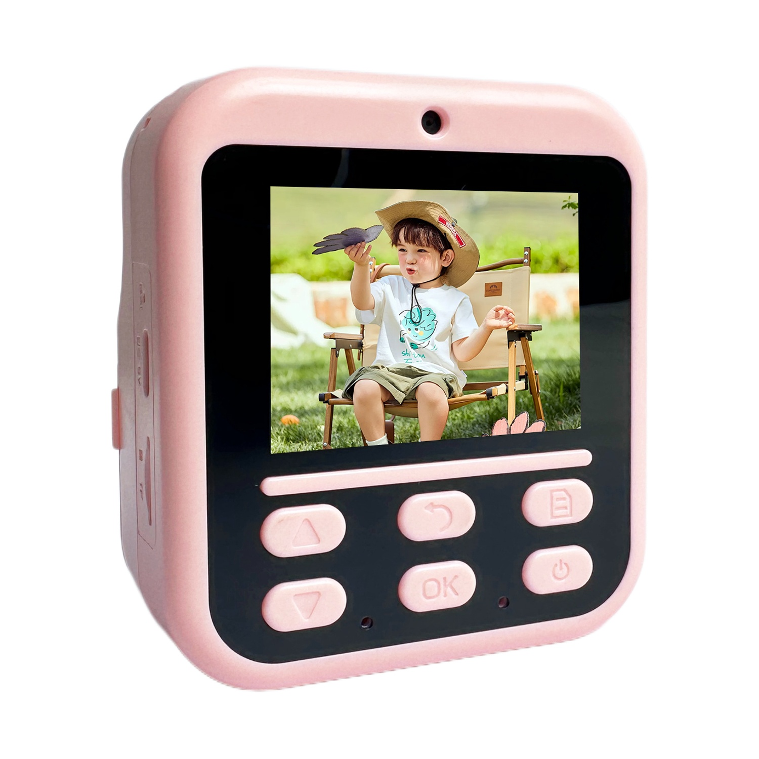 Fotocamera digitale rosa mostra un bambino con cappello che tiene una colomba. Seduto fuori su una sedia.