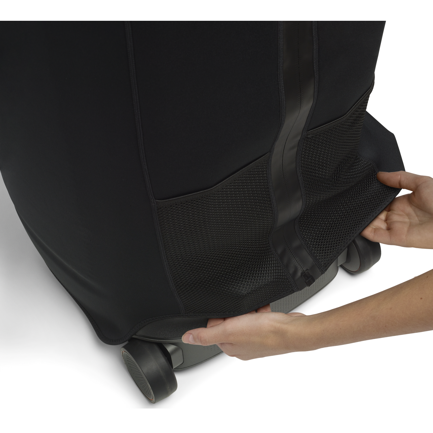 Person pulling black cover over wheels of a suitcase or backpack.