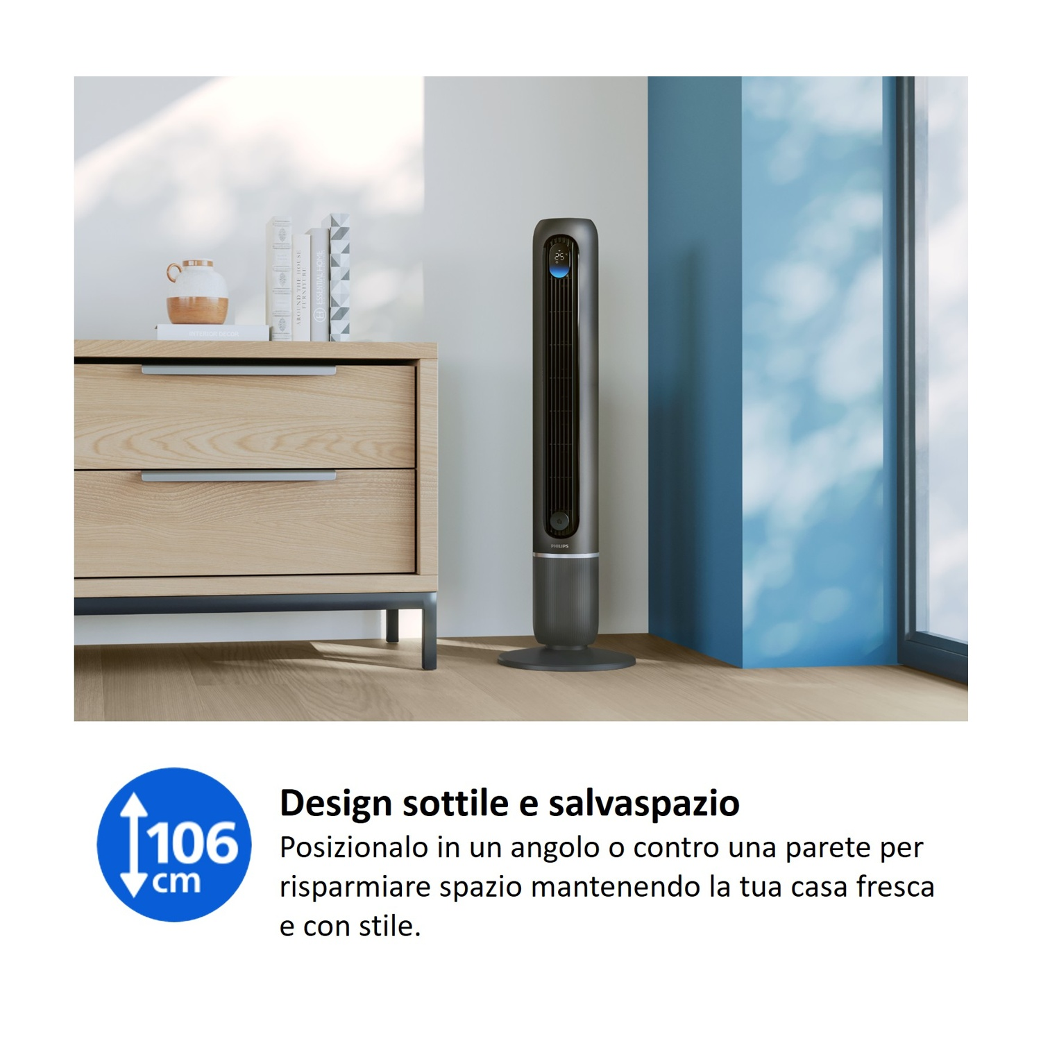 Un ventilatore a torre snello e scuro accanto a un mobile in legno e una finestra.
