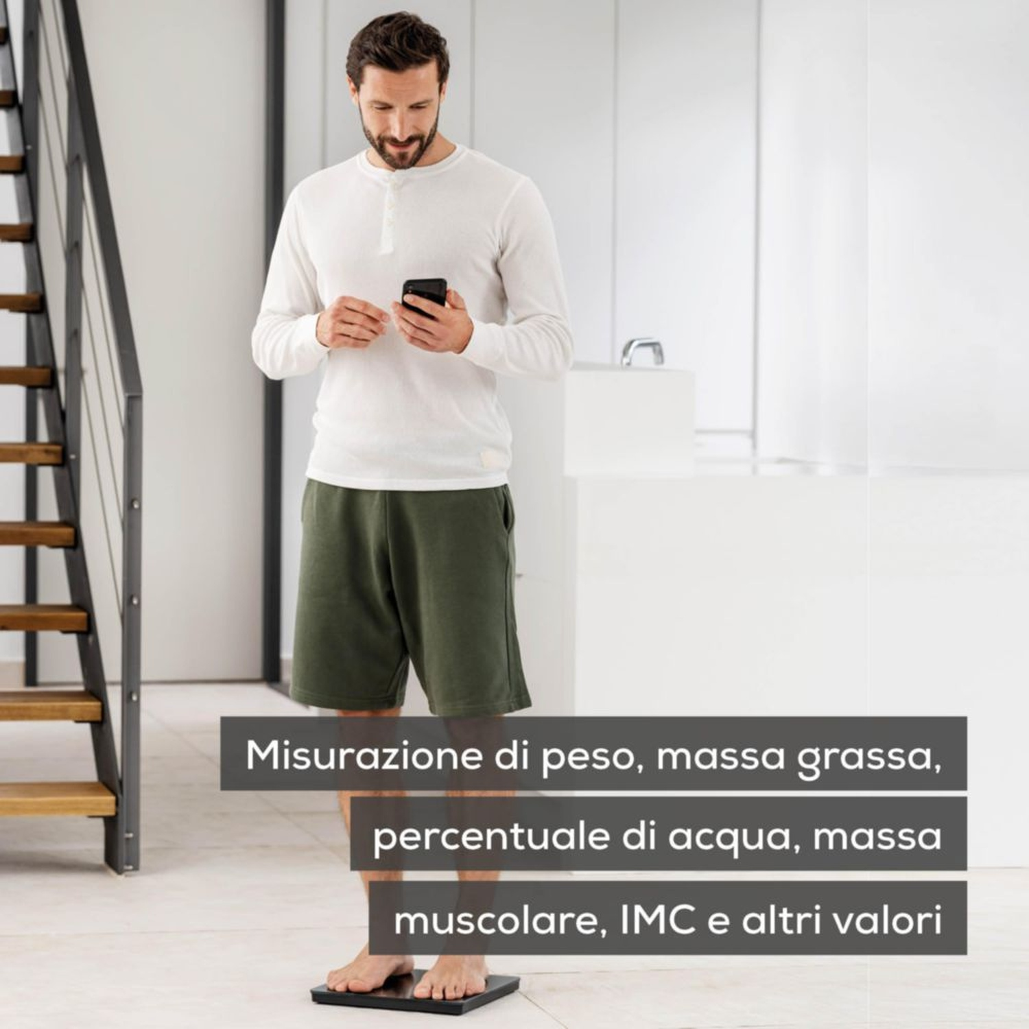 Uomo su bilancia con smartphone. Misura peso, grasso, acqua, muscoli, IMC.
