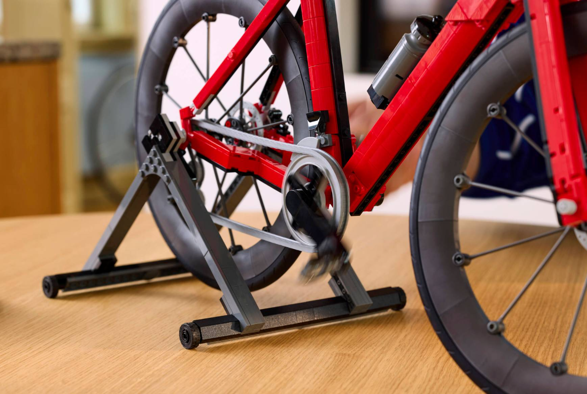 Ein rotes Lego-Fahrrad auf einem Ständer, mit sich drehenden Pedalen.