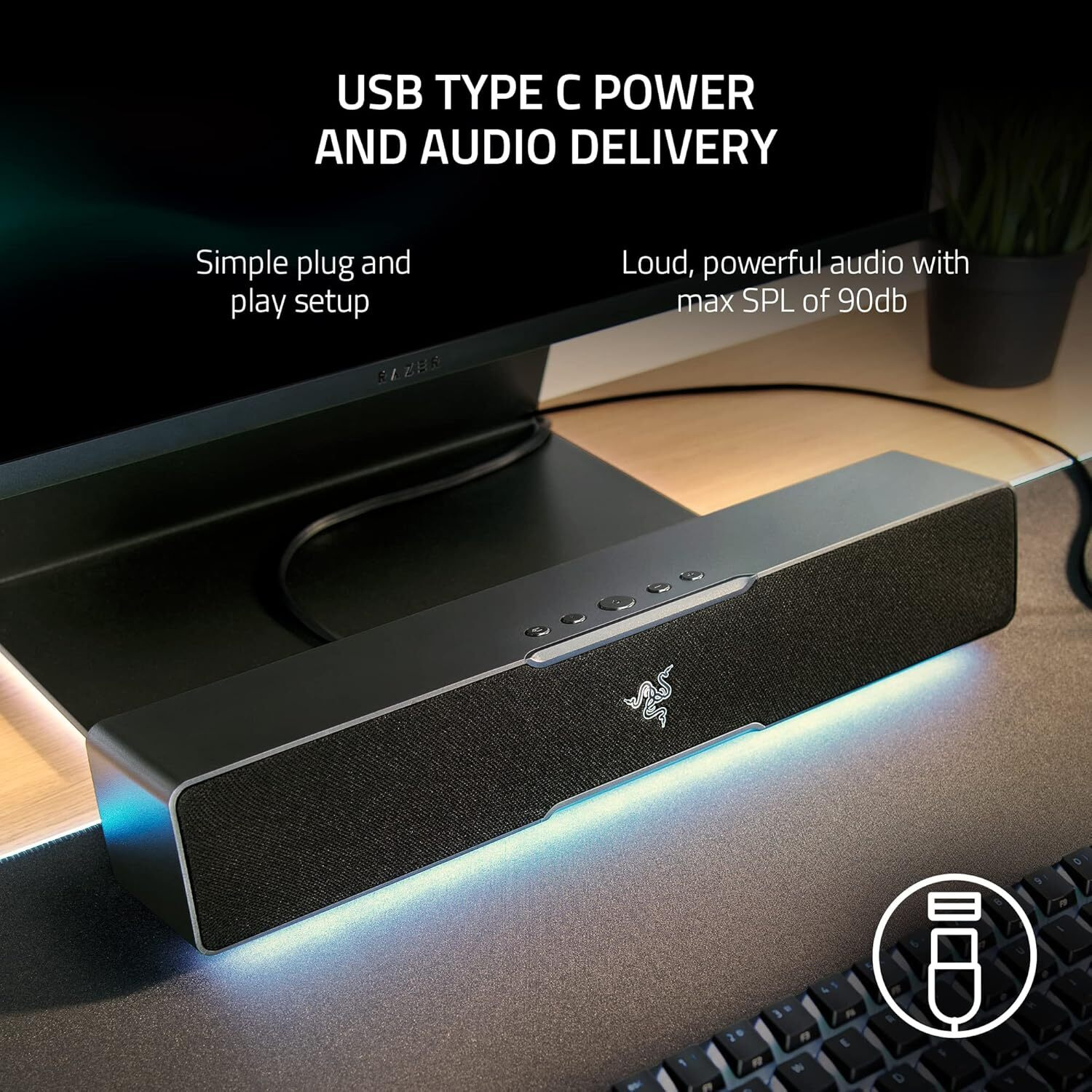 Altoparlante nero con logo Razer, illuminato di blu, su una scrivania.
