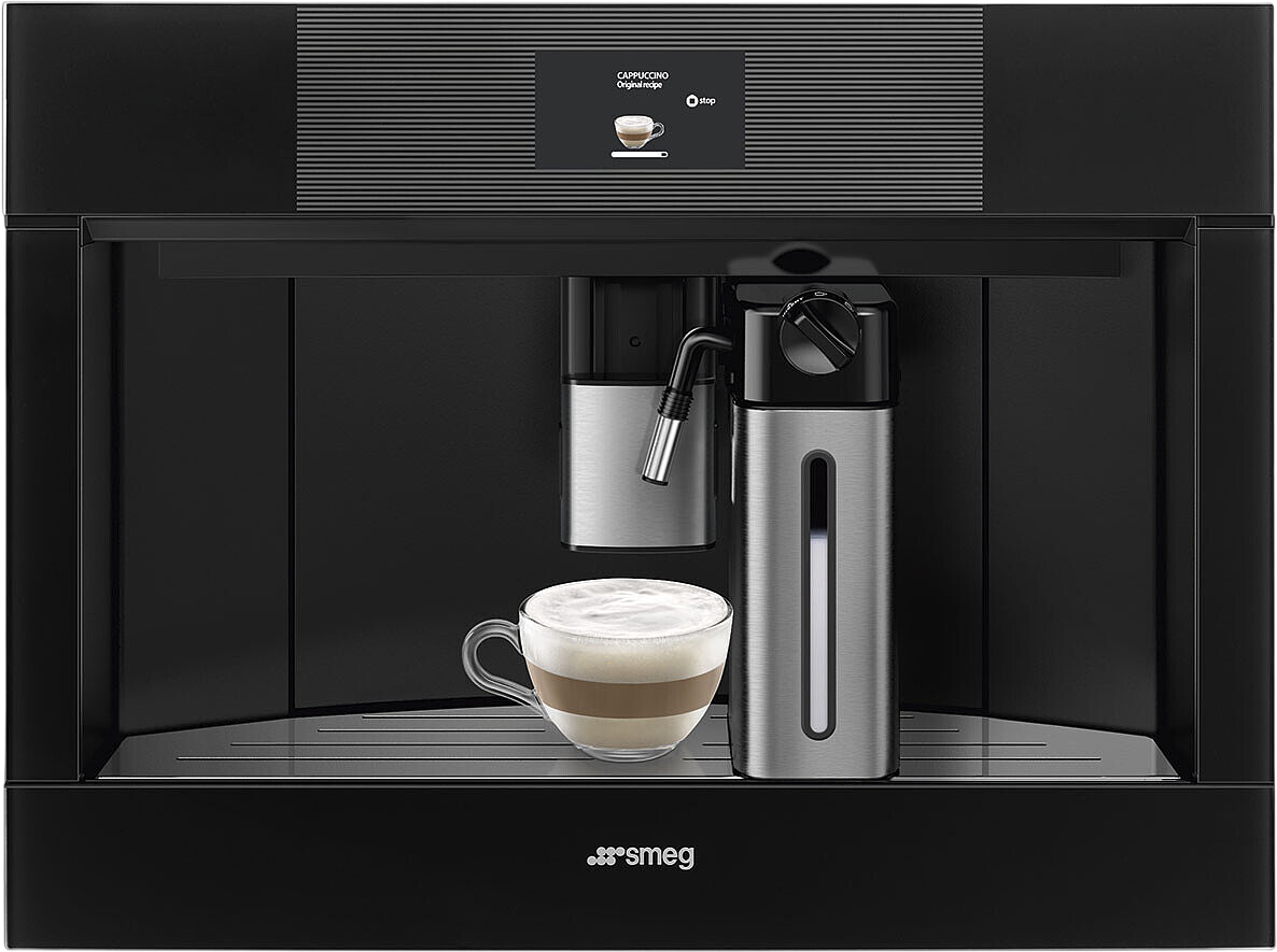 Kaffeemaschine mit Milchschaum in einer Tasse und einem Milchbehälter.