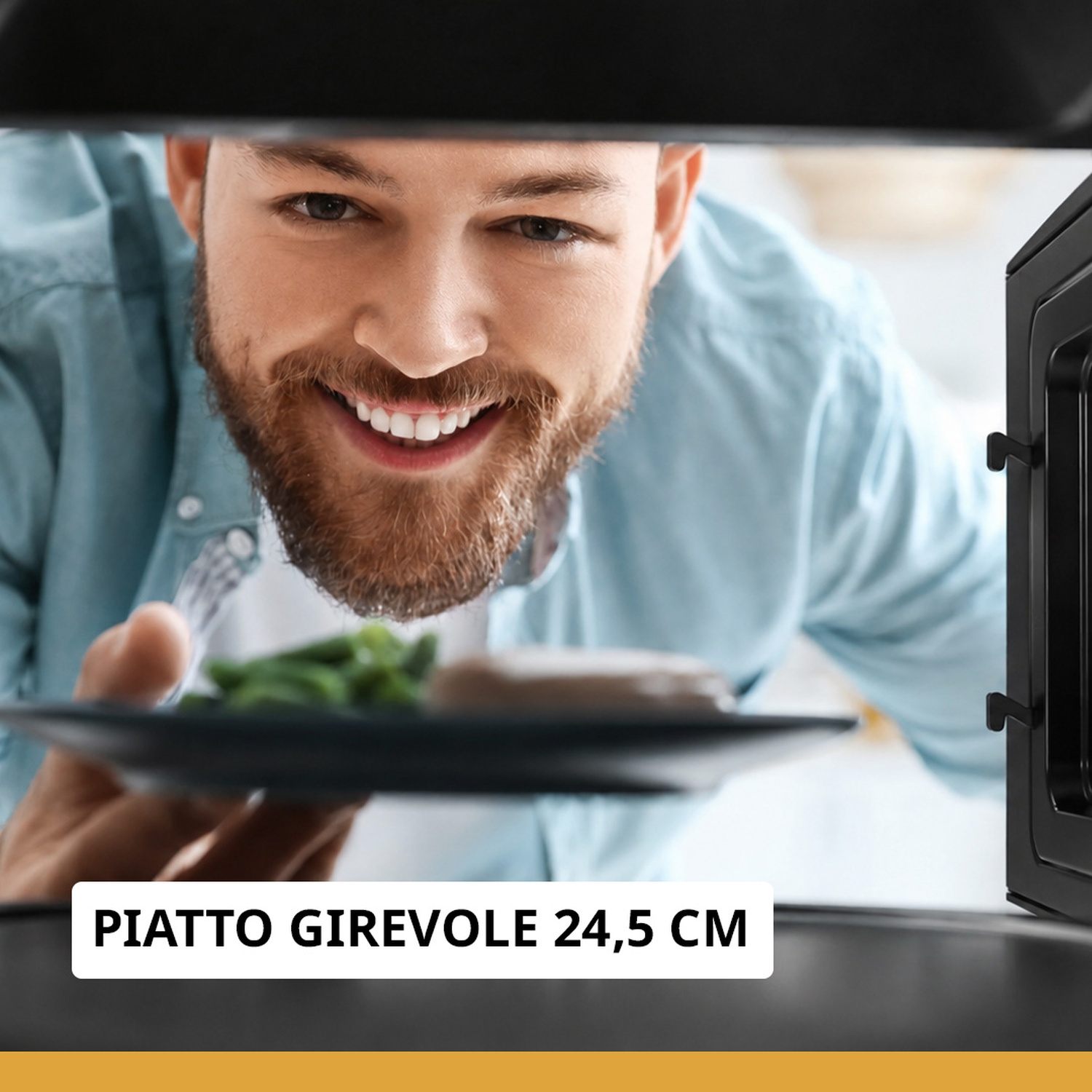 Uomo sorridente con barba mette un piatto di cibo nel microonde.