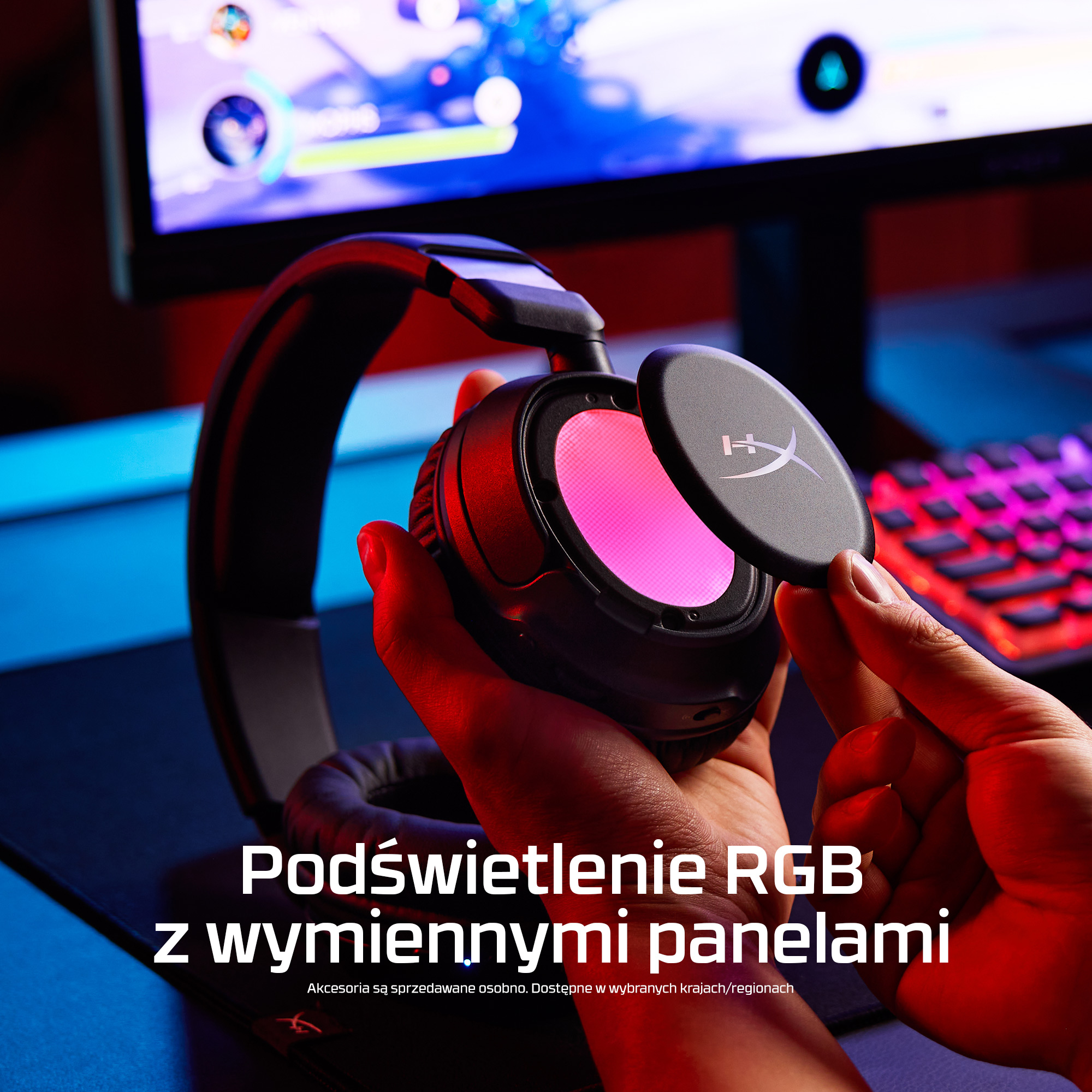 Osoba trzymająca słuchawki z podświetleniem RGB i wymiennymi panelami. Klawiatura w tle.