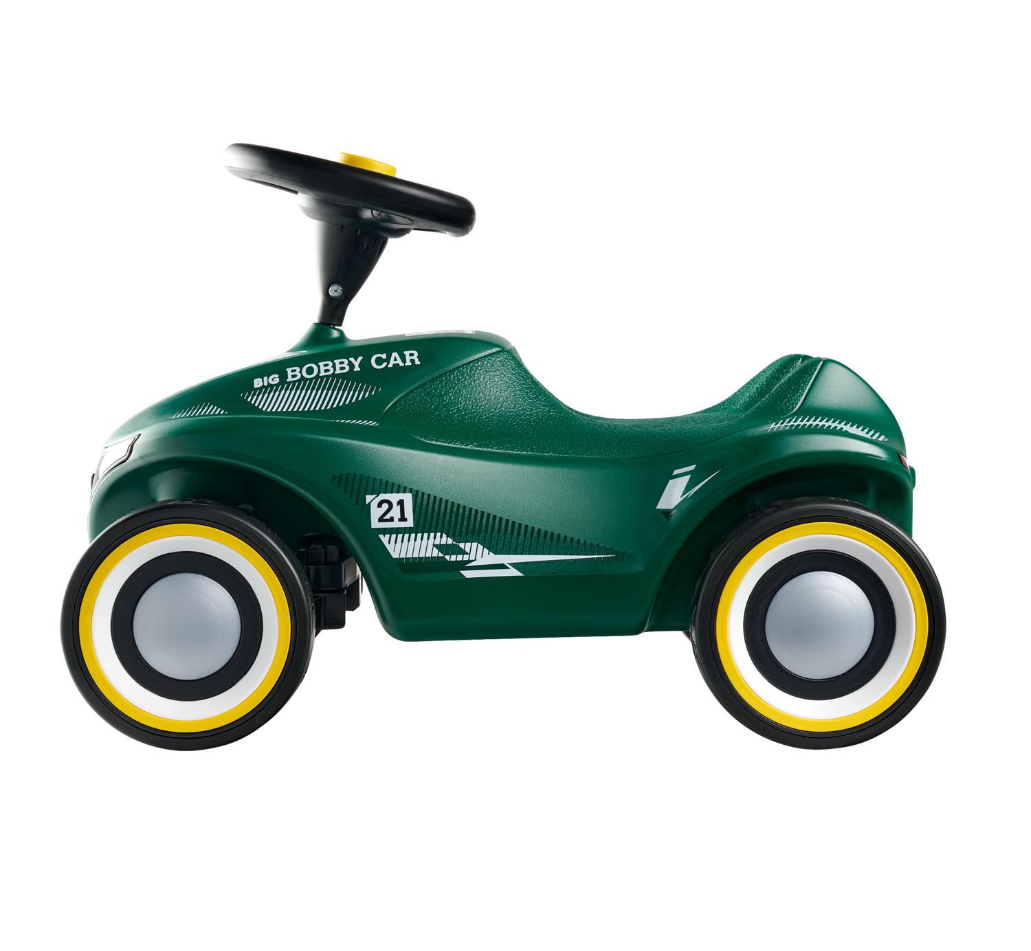 Ein grünes Bobby Car mit gelbem Lenkrad und weißen Aufklebern.