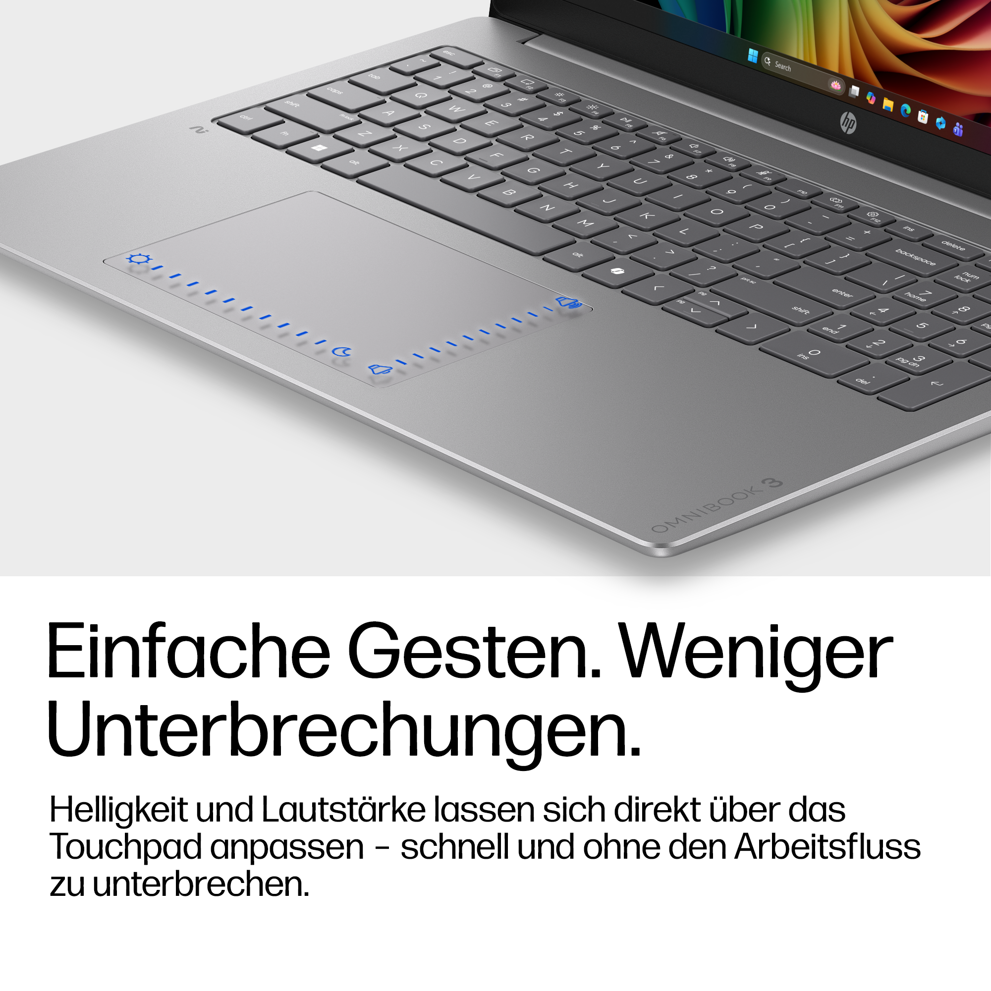 Nahaufnahme eines silbernen Laptops. Das Touchpad hat blaue Symbole. Tastatur und Bildschirm sind sichtbar.